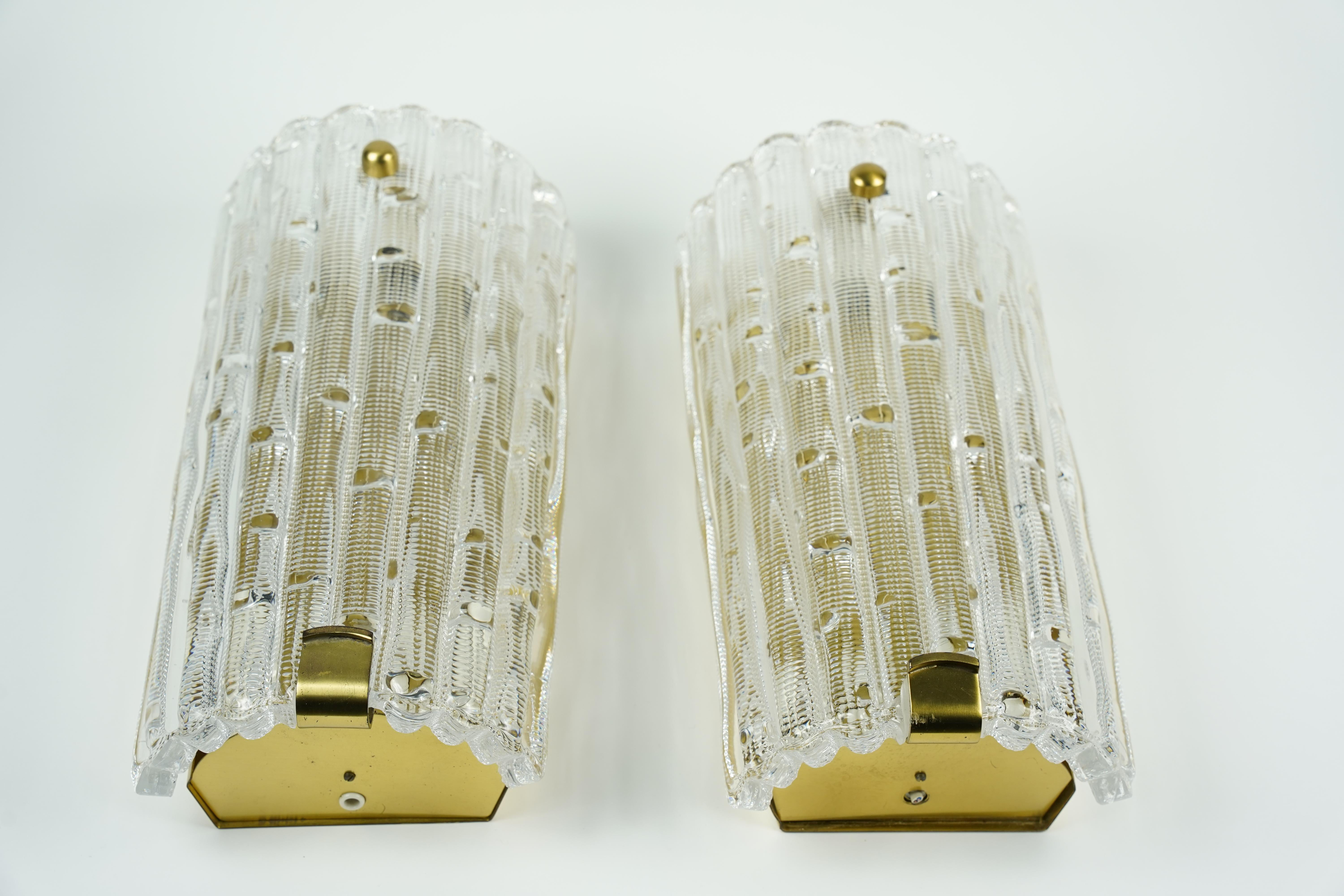 Large pair of Orrefors crystal and brass sconces by Carl Fagerlund, Sweden, 1950, brass frames with three Edison sockets The diffuser is thick crystal shades with details in the glass attached with two brass finials absolutely a Classic piece of