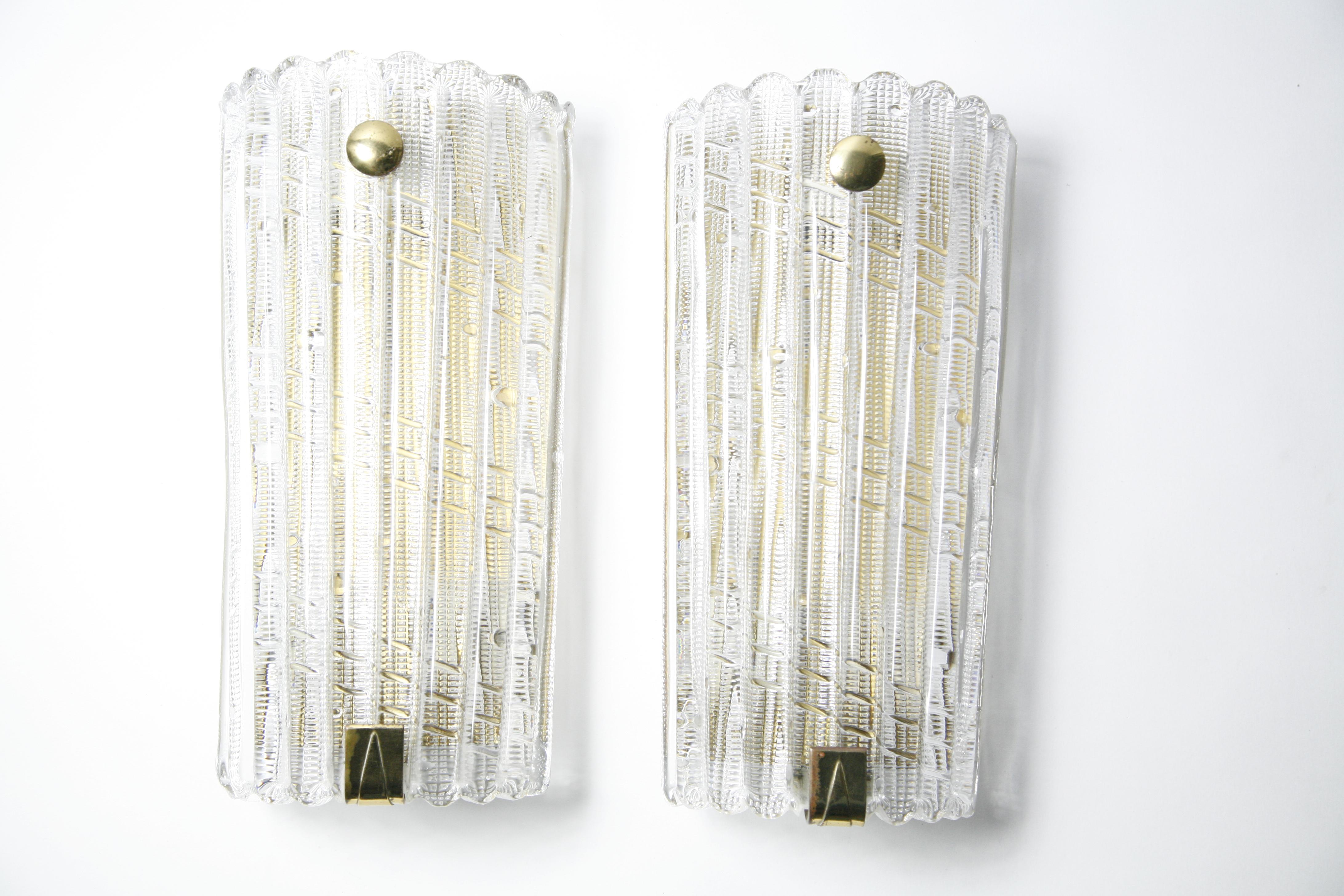 Großes Paar Orrefors Kristall- und Messingleuchten von Carl Fagerlund, Schweden, 1950, Messingrahmen mit drei Edison-Fassungen. Der Diffusor besteht aus dicken Kristallschirmen mit Details im Glas, die mit zwei Messingknäufen befestigt sind. Ein