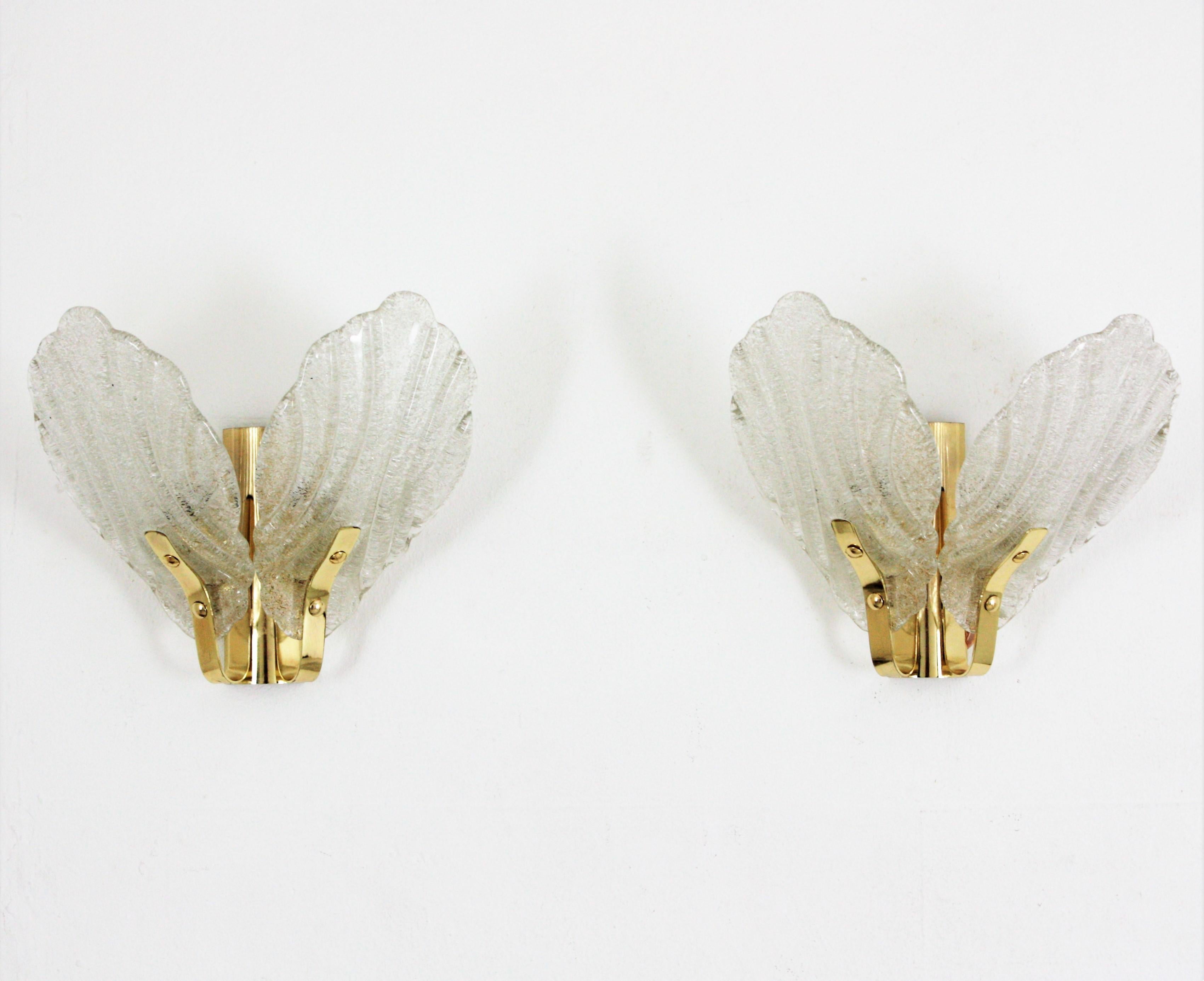 Swedish Modern, Orrefors Fagerlund leaf design double wall lights, glass and brass. 
Designed by Carl Fagerlund and produced in Sweden at the 1960s by the iconic firm of Orrefors. 
Two wall lights with two arms holding leaves glass shades and