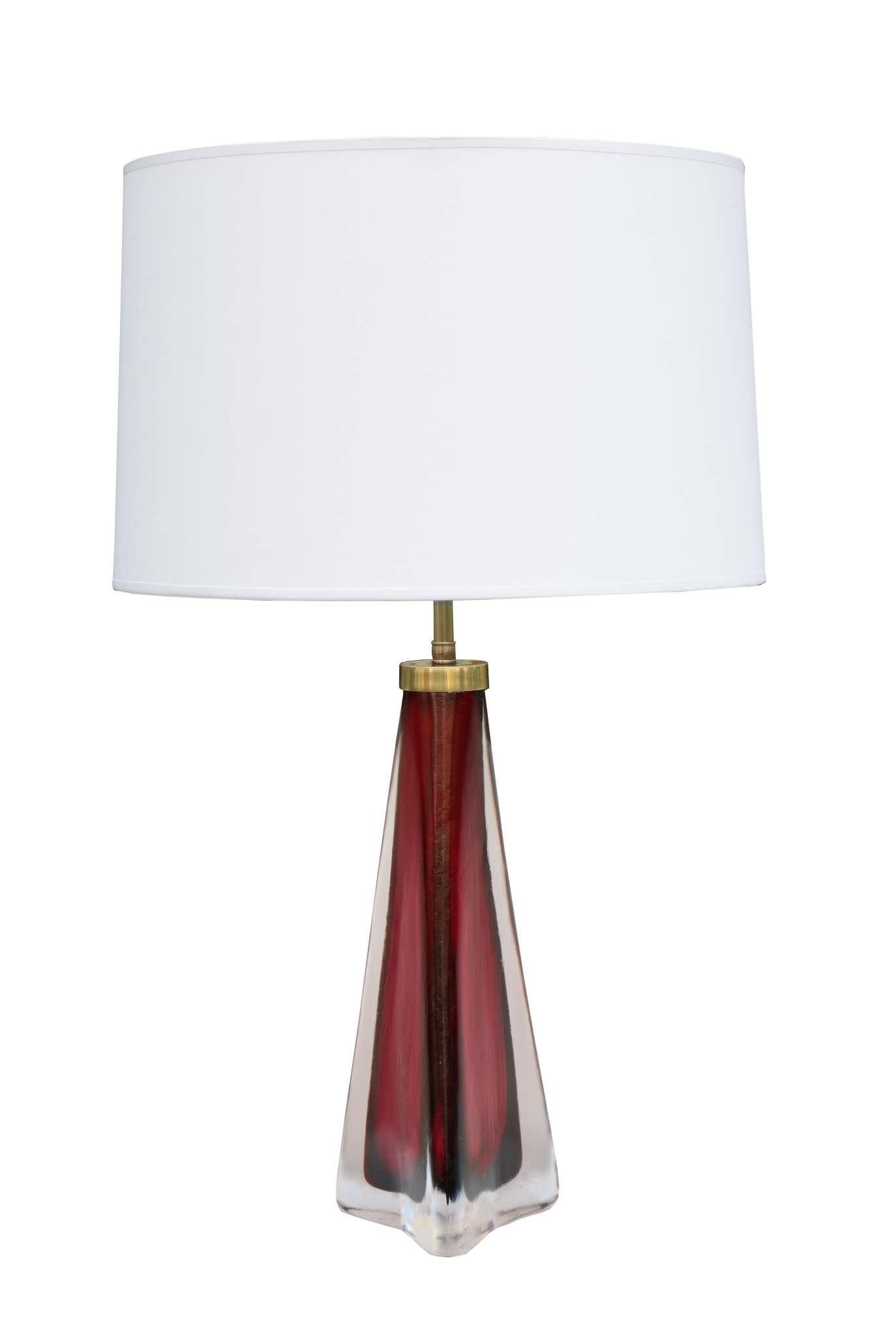 A pair of Orrefors Modernist art glass table lamps. 
Red textured glass in a pyramid shape with patinated brass fittings and details.
With Orrefors signature and label.