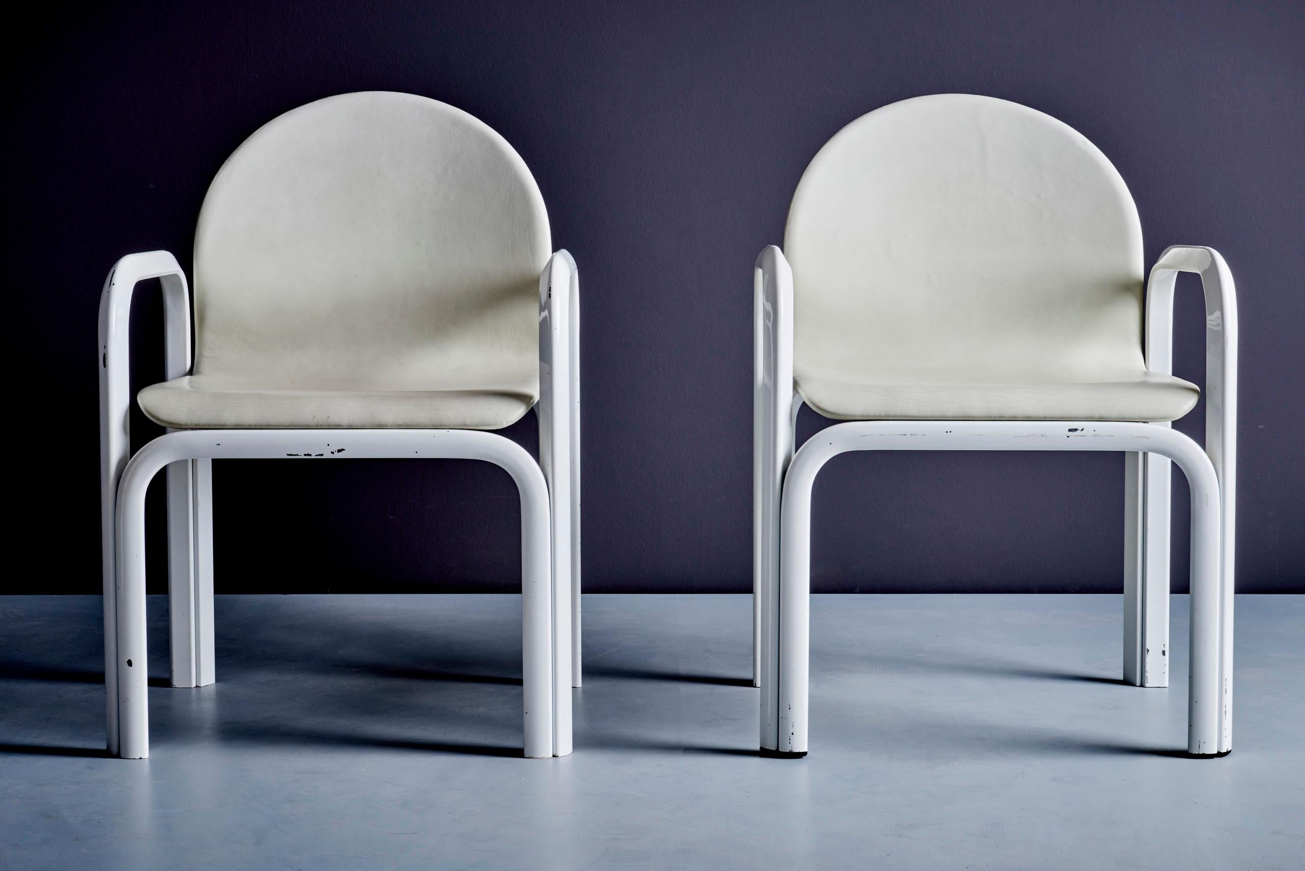 Pair of Orsay armchairs by Gae Aulenti for Knoll, 1975. Made of white leather and lacquered steel, these chairs feature a bold, curved design. They remain in their original vintage condition with visible signs of use, adding to their authentic charm.