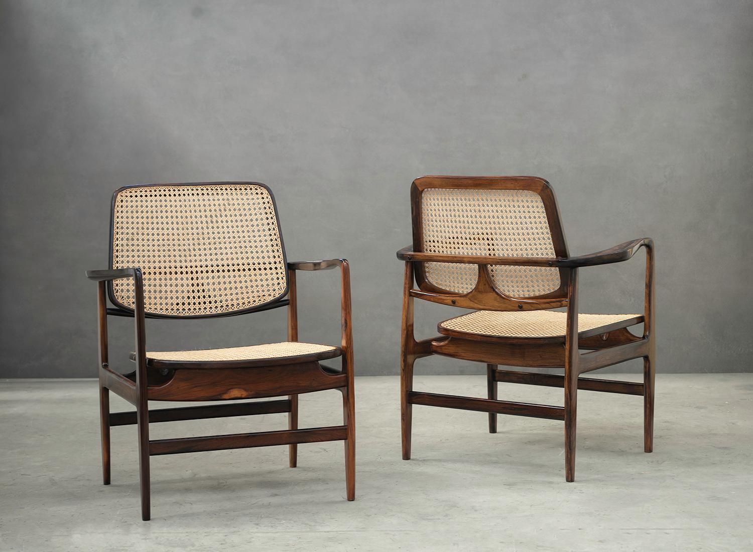 Designed in 1956 by Sergio Rodrigues, this modern pair of armchairs are made of solid rosewood and straw.

Created by Sergio Rodrigues in 1956, initially for the Jockey Club of Rio de Janeiro, the 