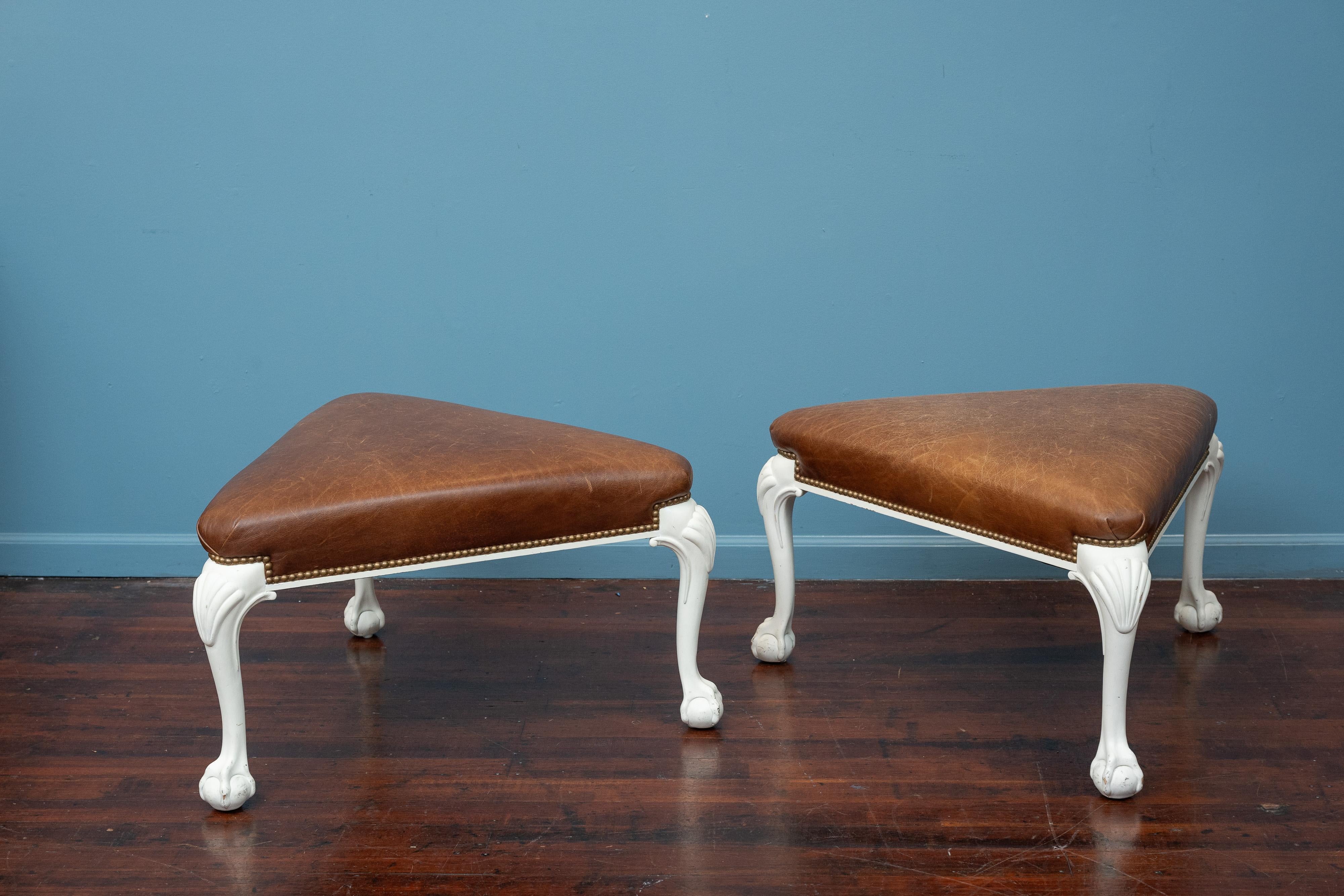 Pair of Oscar de la Renta design chippendale contemporary ottoman. Carved decorative ball and claw foot painted legs. Upholstered in patinated leather with brass nail head trim, signed.