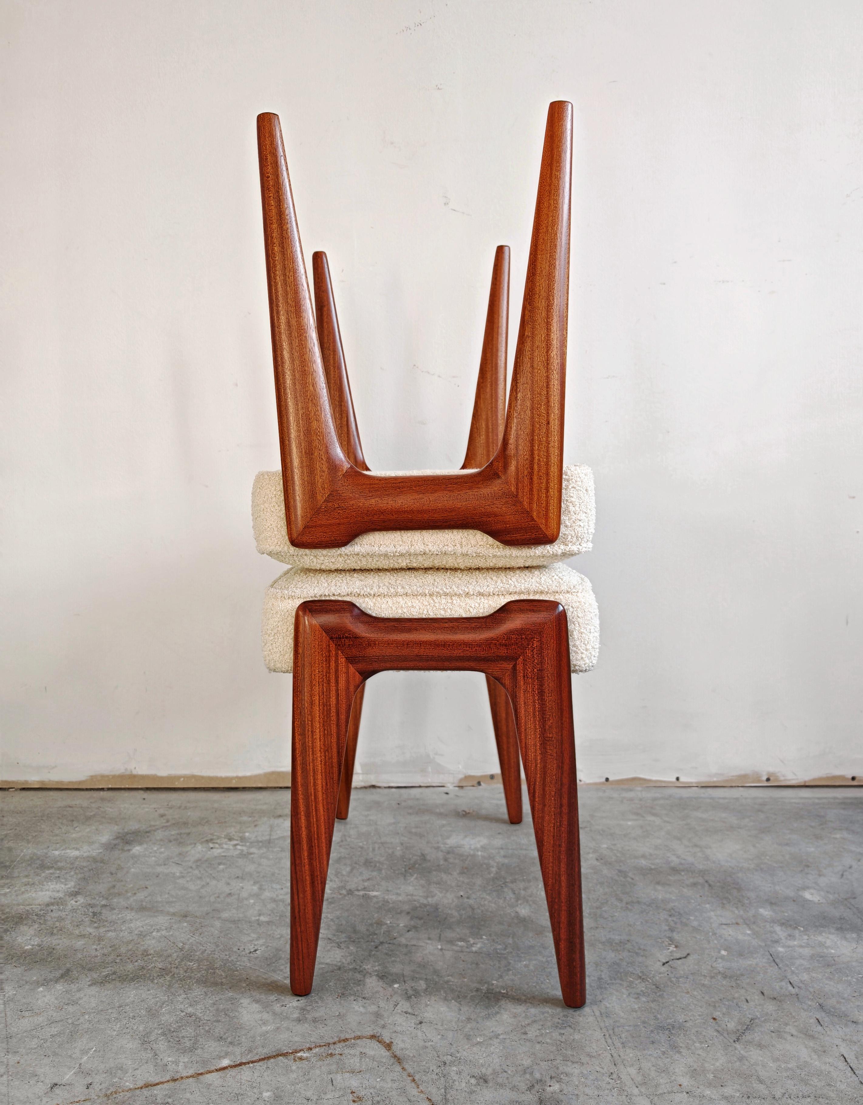 In this listing you will find a pair of Mid Century Modern ottomans or stools done in solid mahogany and upholstered in off-white boucle creating a beautiful contrast between sleek shape of the wood legs and texture of the fabric. They were designed