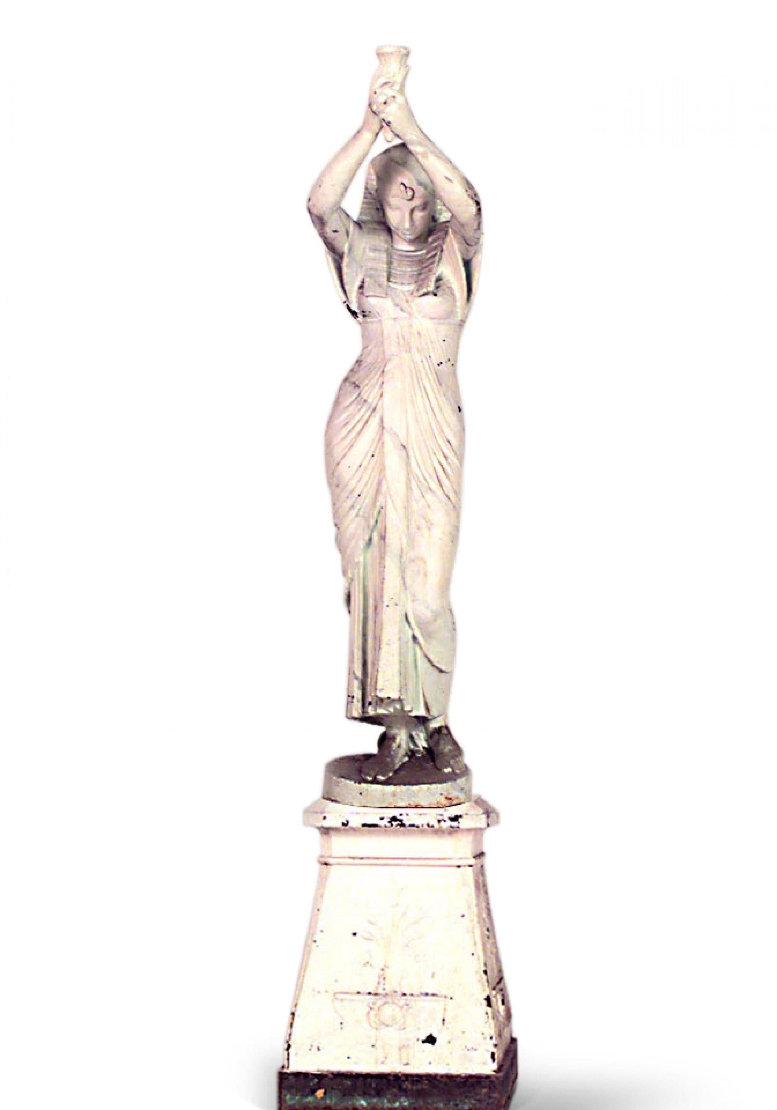 Pair of Outdoor French Egyptian Revival style cast iron women, each holding a torch aloft and standing on spreading square bases (mid 19th Cent., attr. Val D'Osne)

