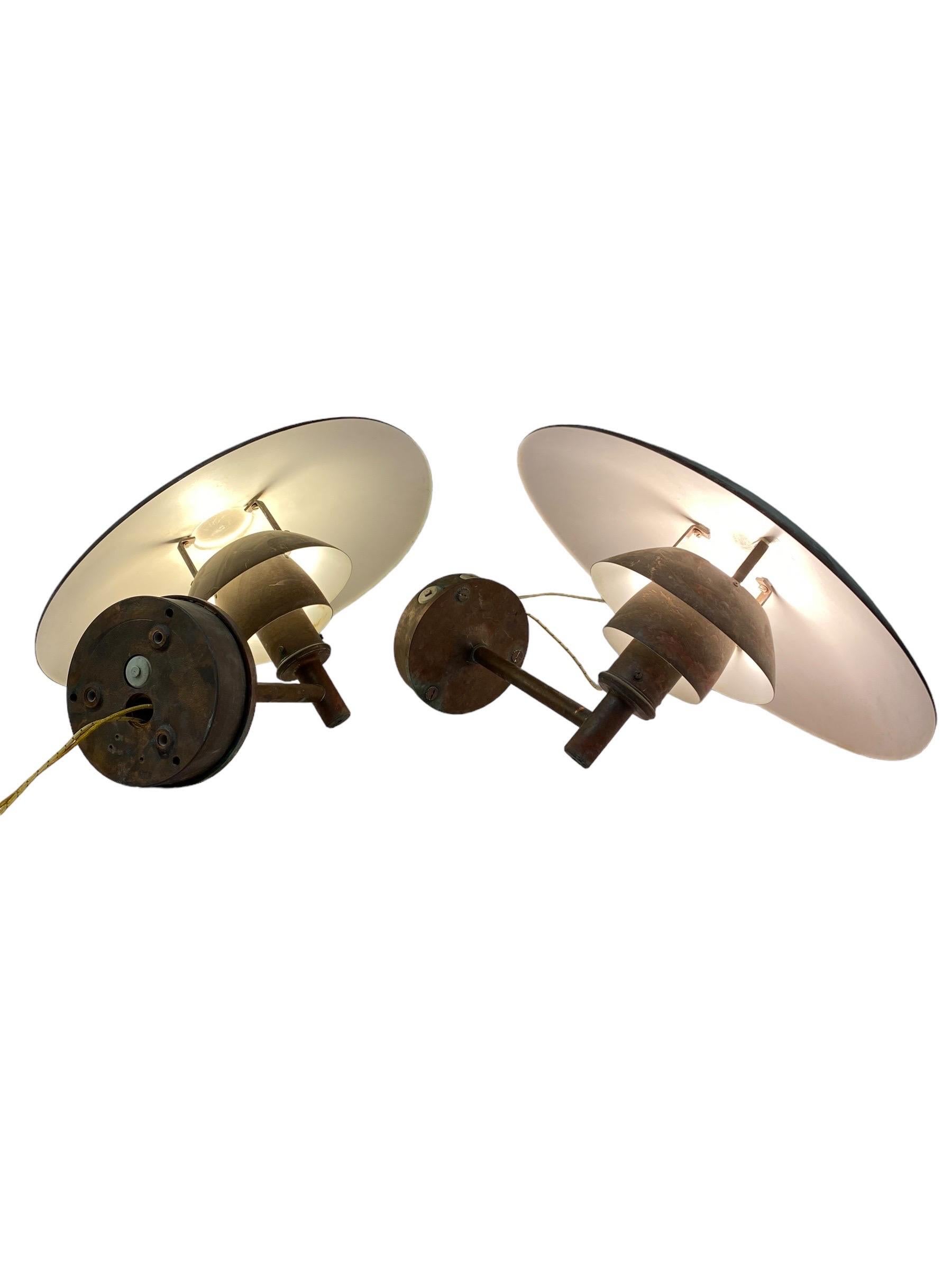 A gorgeous pair of Poul Henningsen PH wall lamps for Louis Poulsen in patinated copper. These beautiful examples came from a swimming hall and have extra nice patina due to the humid space they were in. The lamps are in very good condition and