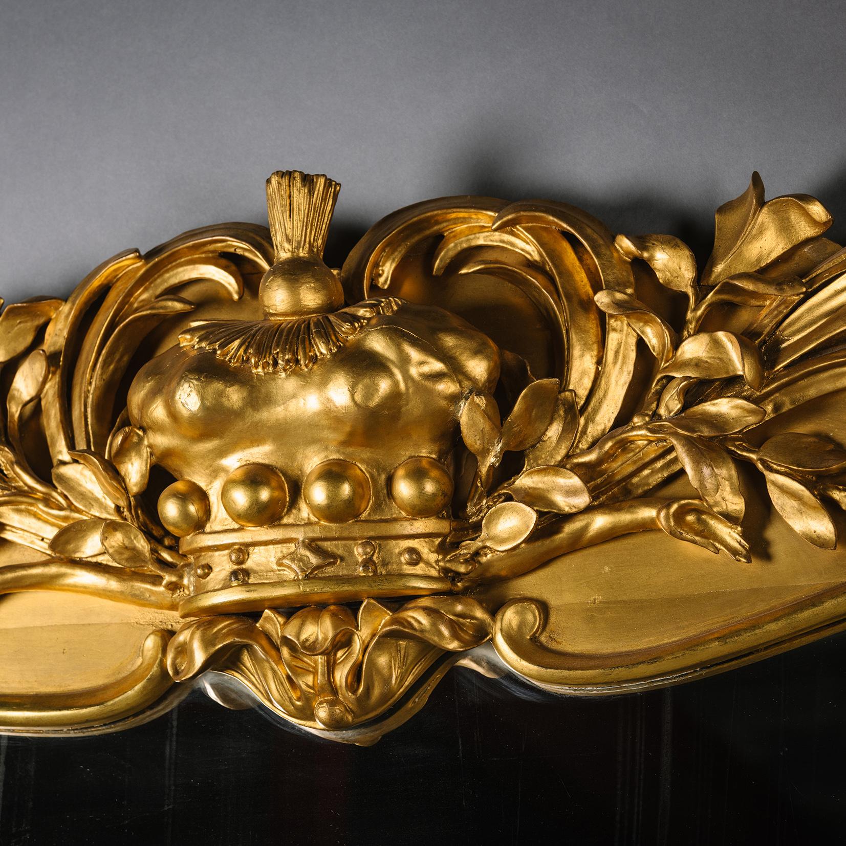 Un inusual espejo de madera dorada tallada, posiblemente escocés.

La cresta arqueada está elaboradamente decorada con madera dorada tallada y gesso, con una corona de barón rodeada de hojas de acanto barridas y ramas de laurel. Los laterales del