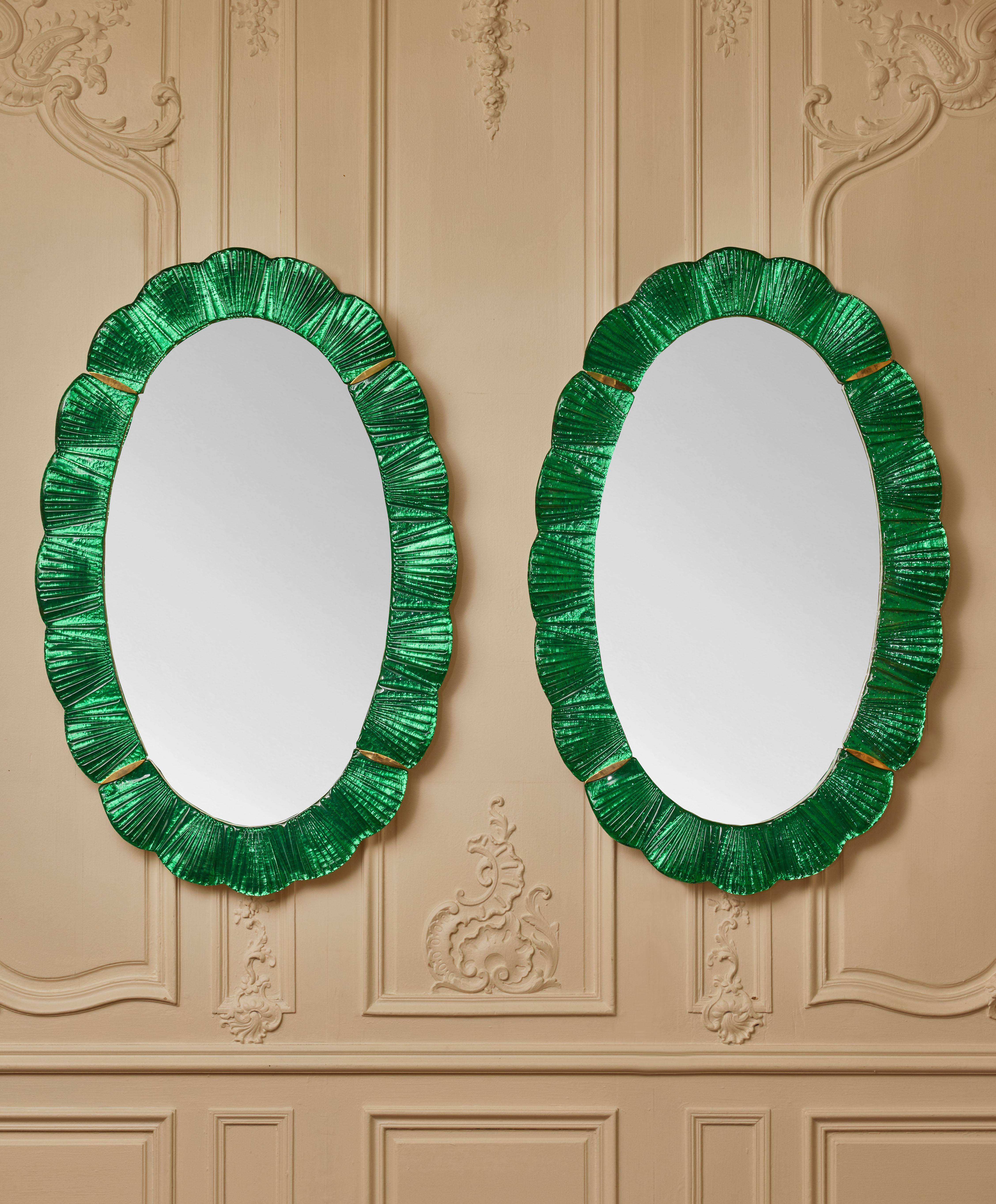 Pair of oval mirrors with frame in sculpted Murano glass and brass inlays.
Creation by Studio Glustin.