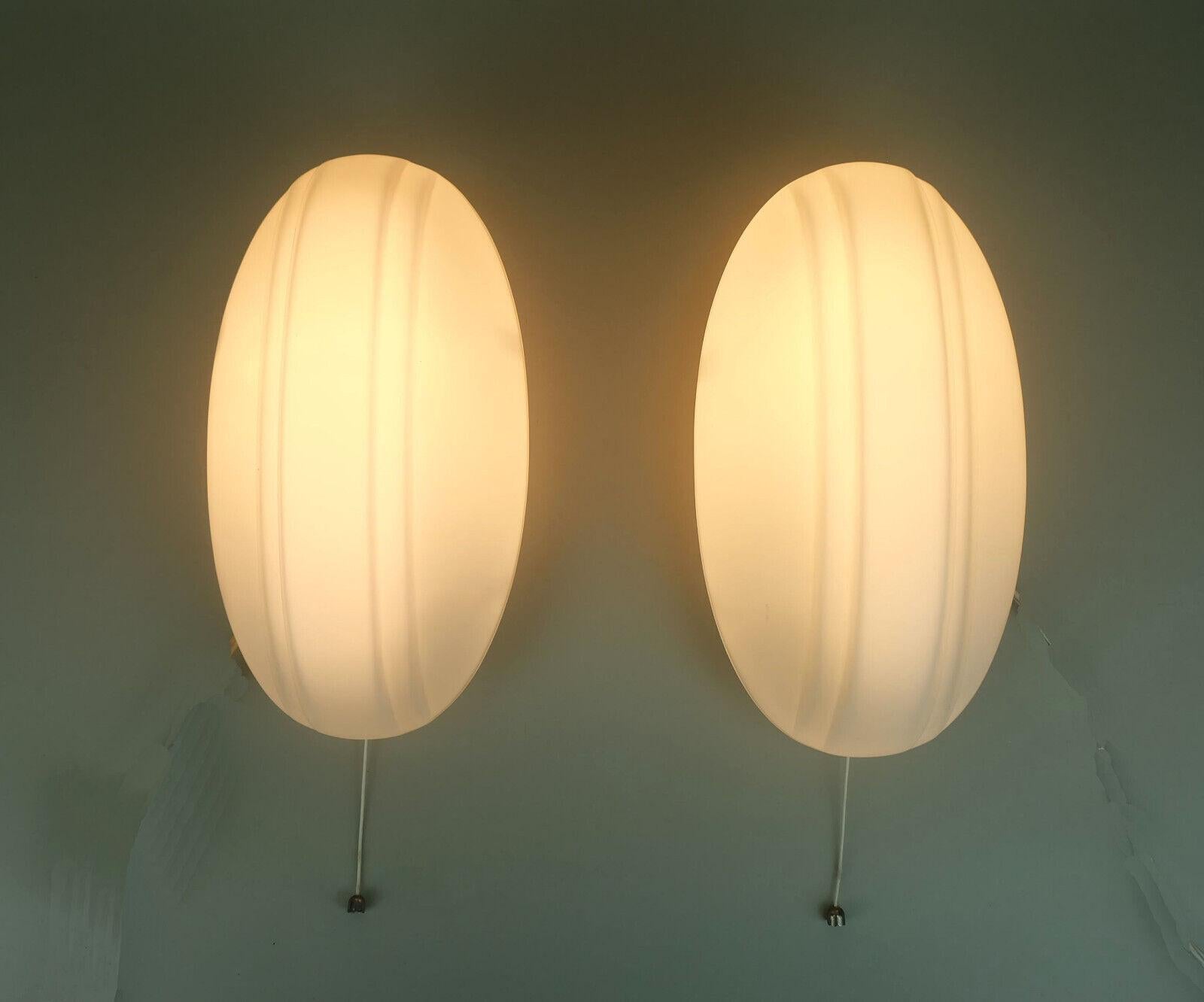 Pair of 1970s 80s sconces manufactured by Putzler. Matt white opaline glass shades, base white lacquered metal. Holds 1 E27 light bulb each.

A matching flush mount is available.

Dimensions in cm: 
Length 25.5 cm, width 14 cm, depth 12