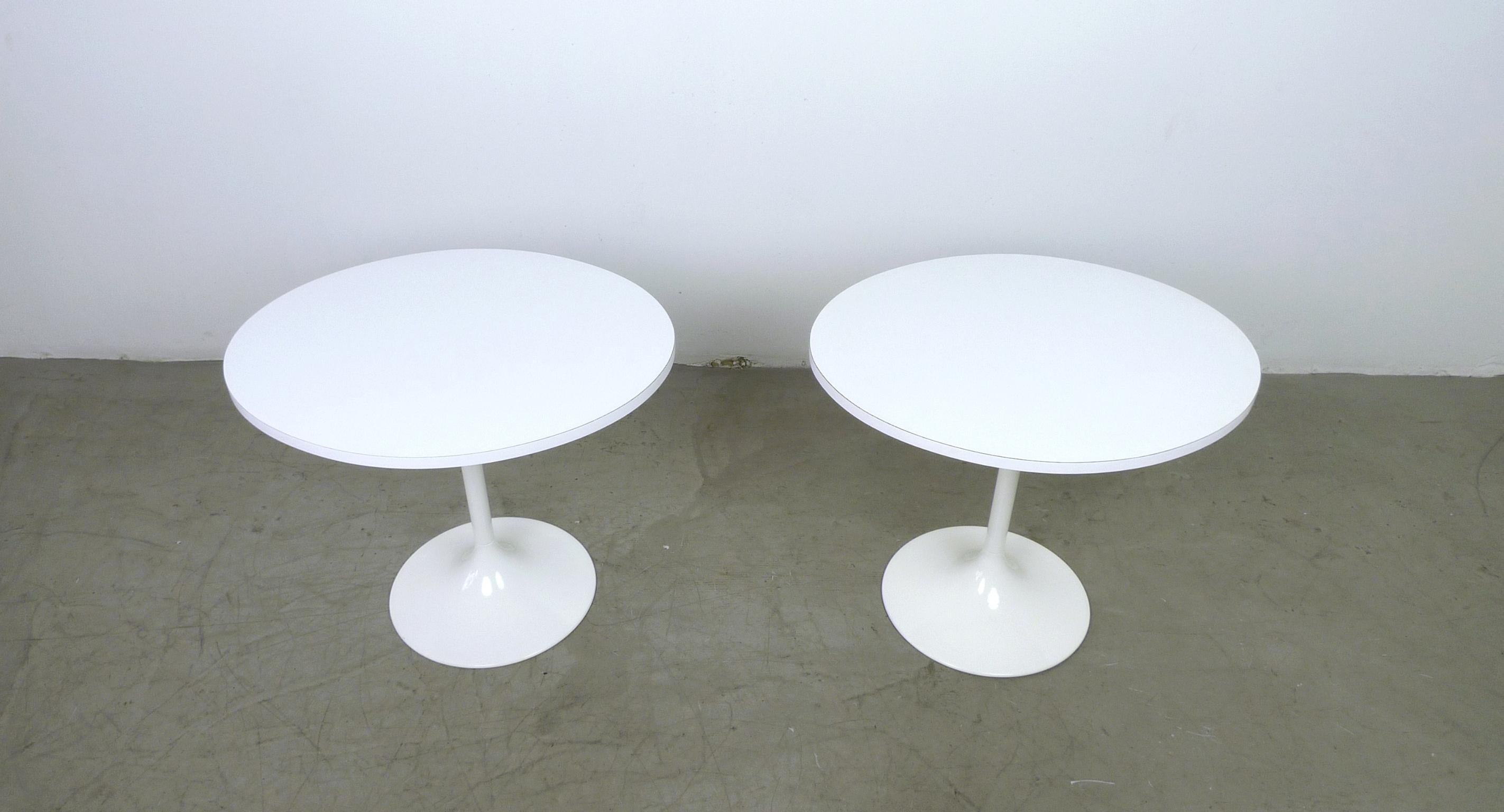 This pair of white side tables features oval tops and painted metal tulip bases. The tables were produced in Germany in the 1970s and they are in very good condition.