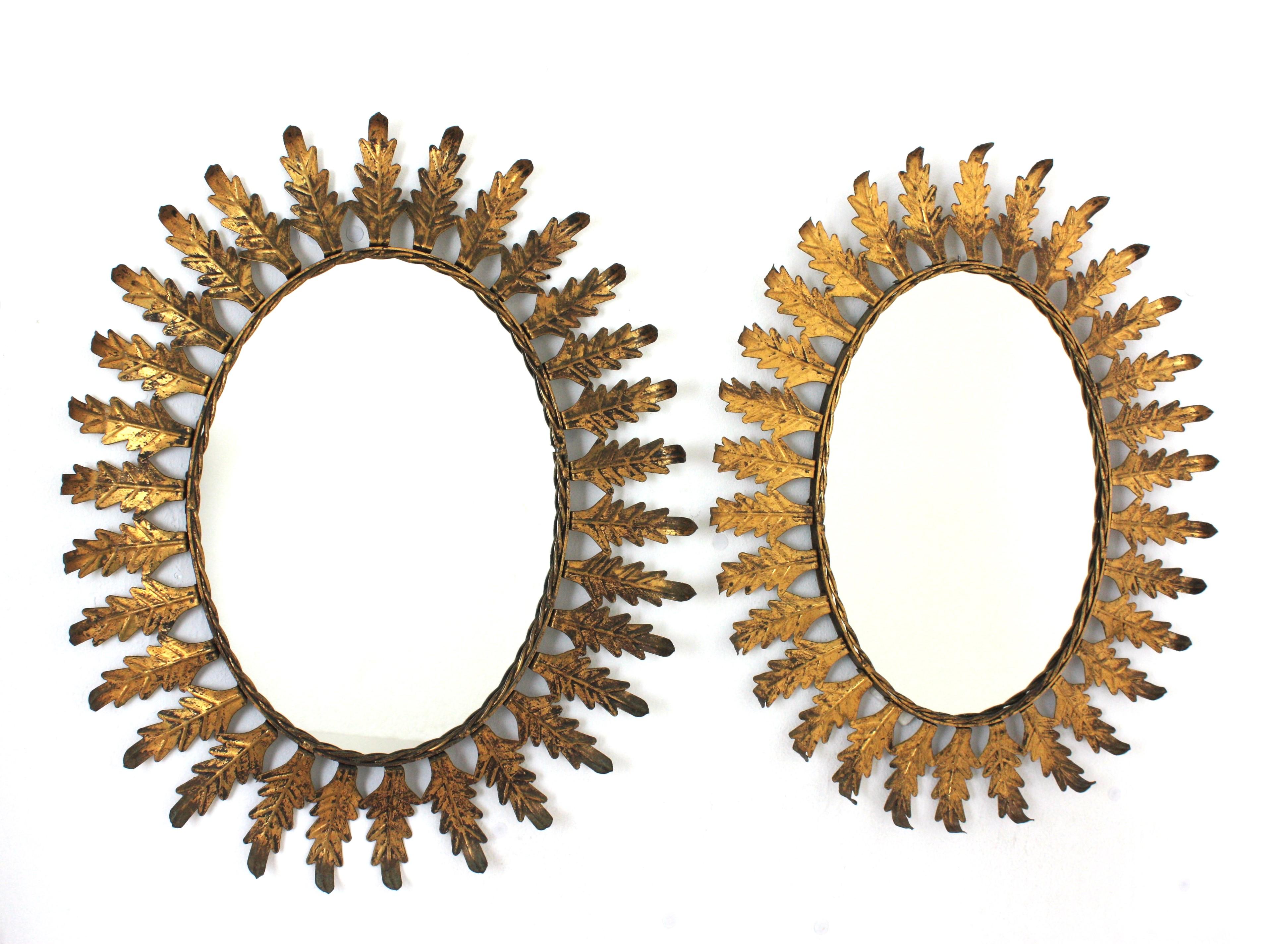 Pareja de Espejos Ovalados Sunburst, Metal Dorado
Llamativo par de espejos de pared ovalados de estilo Moderno de Mediados de Siglo con hojas de metal y acabado en pan de oro, España, años 50.
Estos espejos de sol con hojas, muy decorativos, tienen