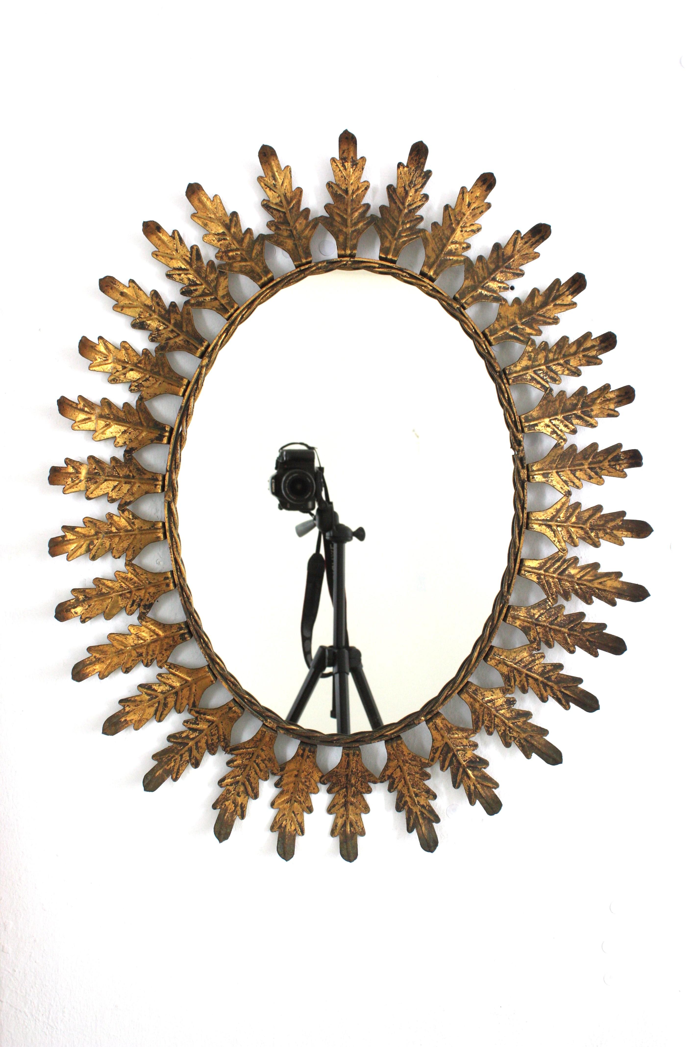 Pareja de Espejos Ovalados Sunburst en Hierro Dorado con Marco de Hojas, España Años 50 Español en venta