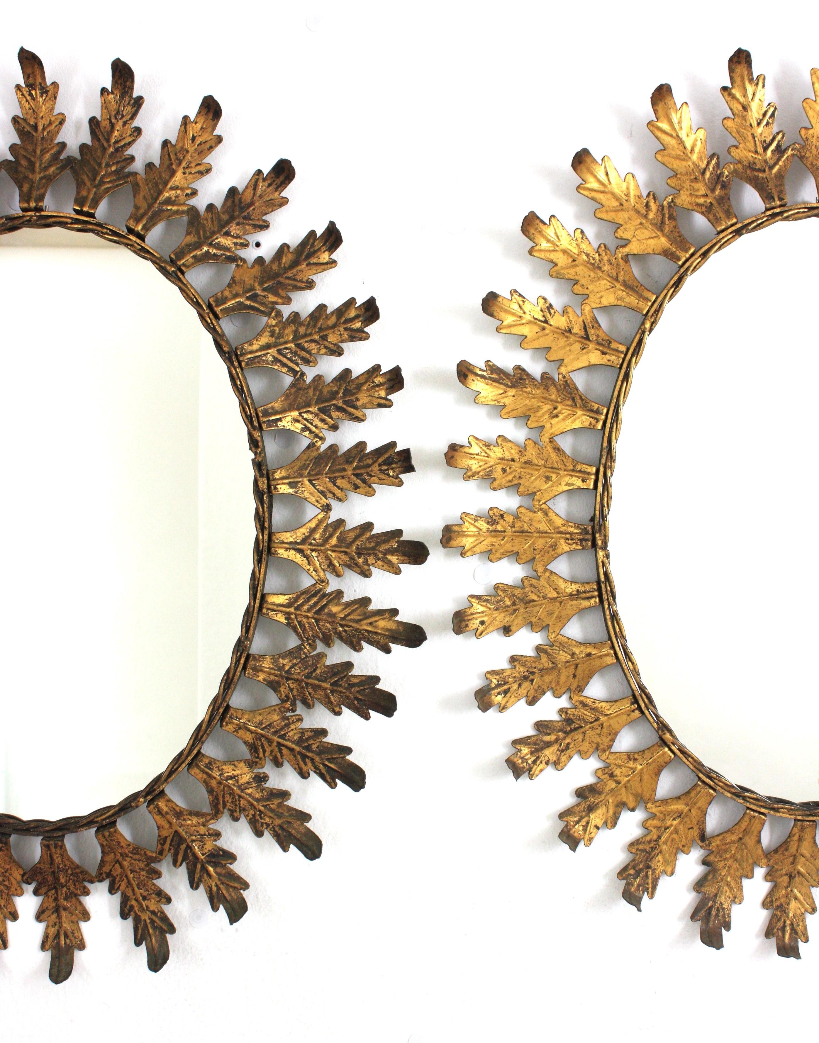 Pareja de Espejos Ovalados Sunburst en Hierro Dorado con Marco de Hojas, España Años 50 siglo XX en venta