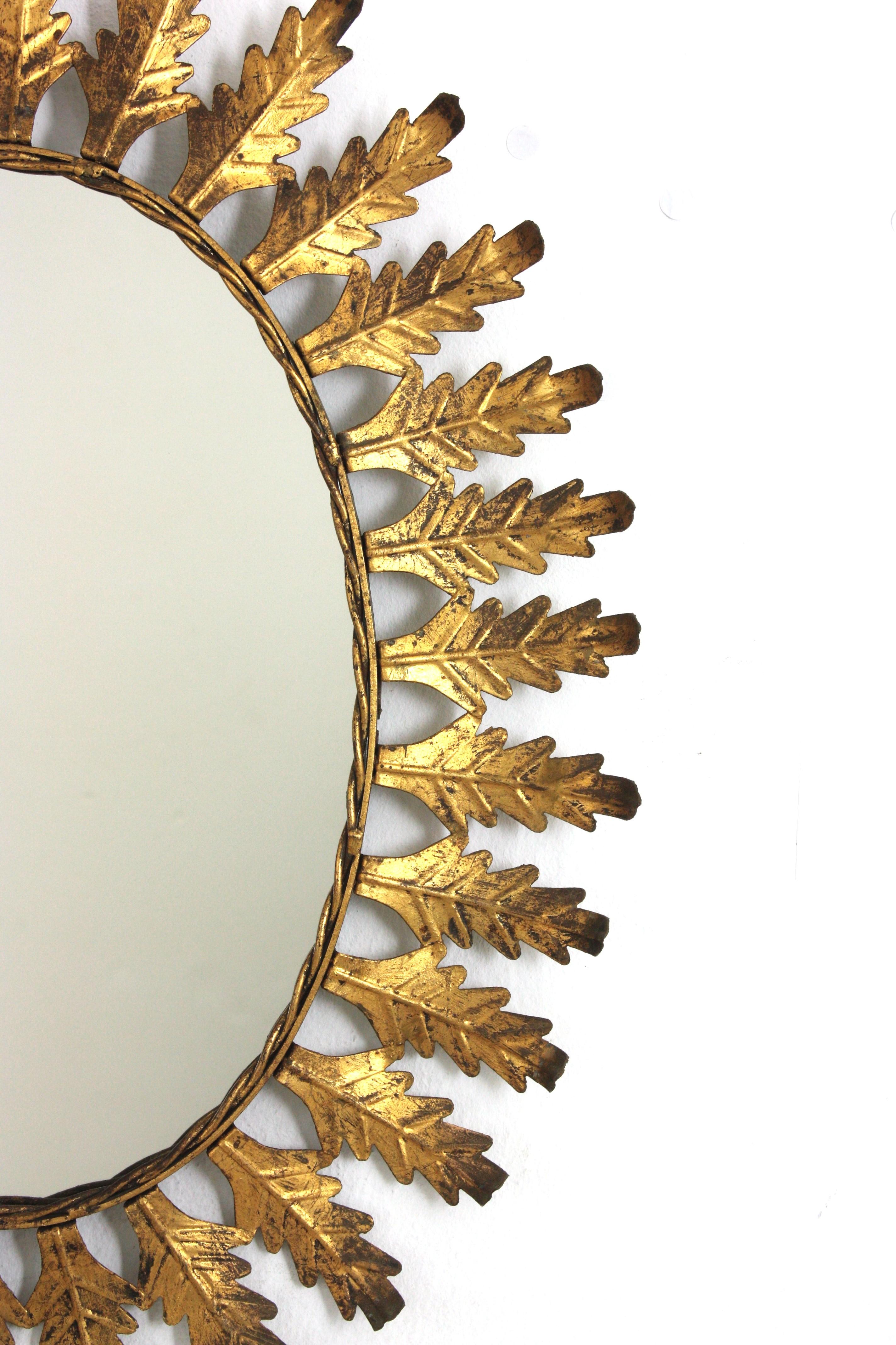 Pareja de Espejos Ovalados Sunburst en Hierro Dorado con Marco de Hojas, España Años 50 en venta 2