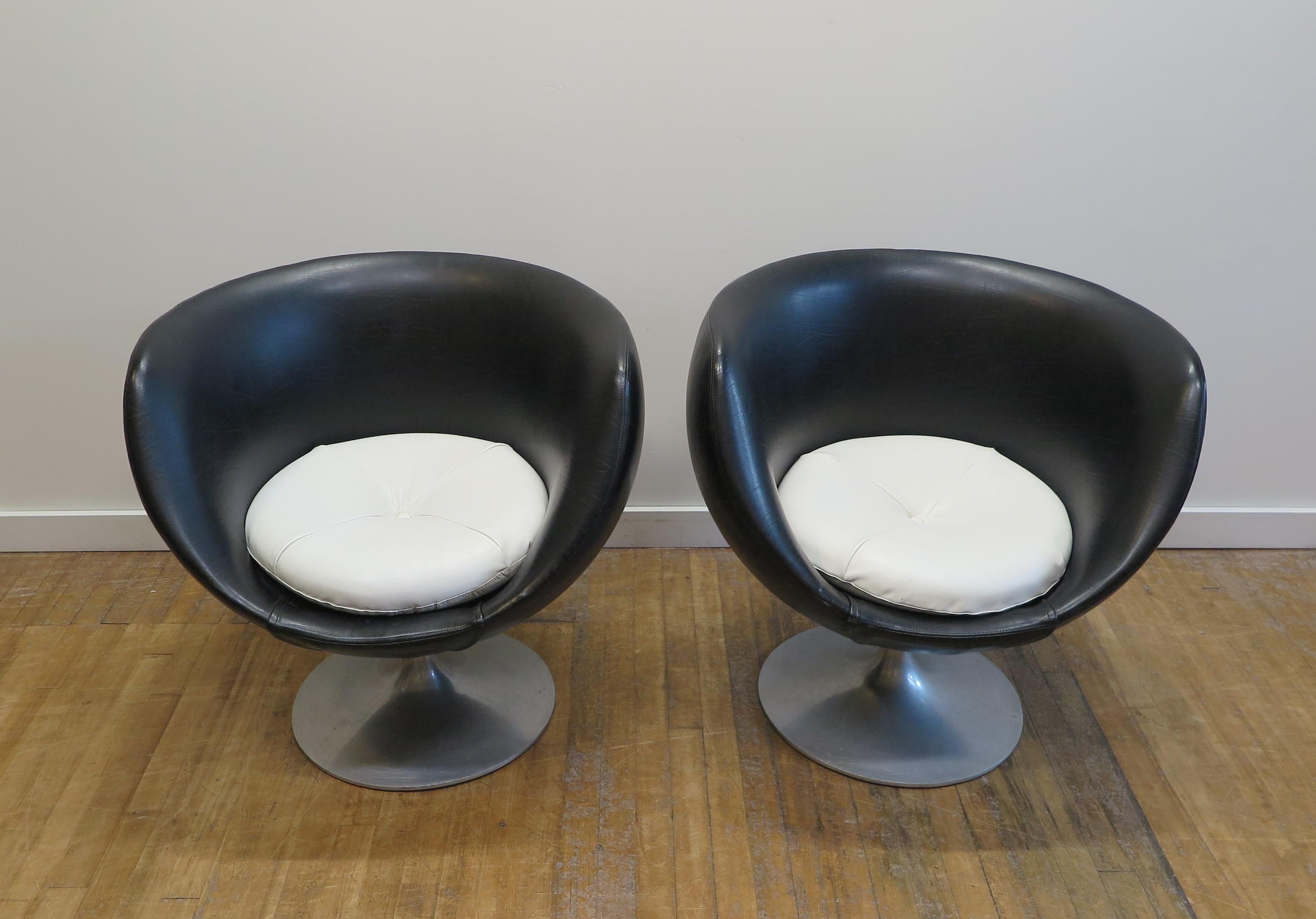 Ein Paar Overman Pod Chairs. Seltene frühe Tulpenfuß-Drehstühle von Overman. Overman Swivel Pod Stühle mit dem frühen Tulpenfuß. In gutem Originalzustand, kann so verwendet werden, wie es ist. Aus schwarzem Kunstleder mit weißen Kunstlederpolstern.