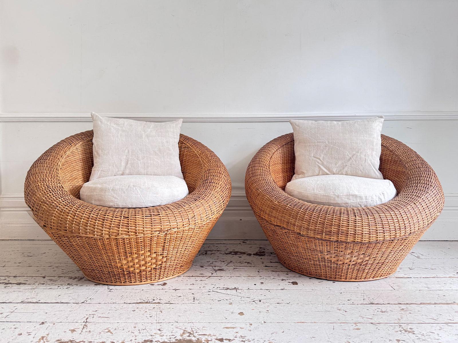 A striking and oversized pair of French lounge chairs dating to the 1970s, expertly crafted in round rattan. These iconic chairs combine sculptural form with supreme comfort, their generous circular frames enveloping the sitter in a sense of relaxed