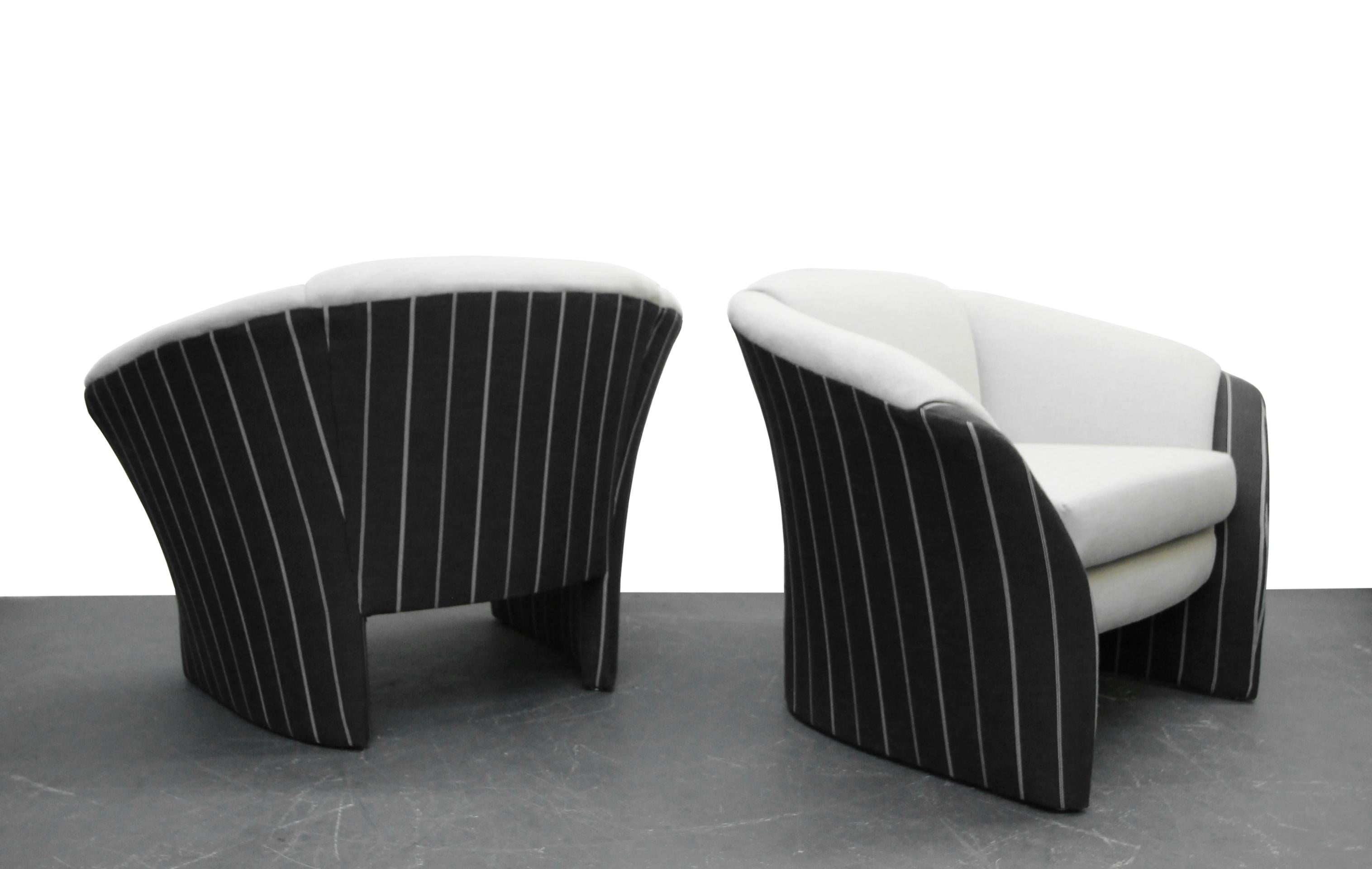 Beautifully restored pair of oversized barrel back lounge chairs with splayed arms. Check out those lines.

Chairs have been restored with all new foam and a handsome pale grey and charcoal grey pinstripe fabric. Ready to go straight to their new