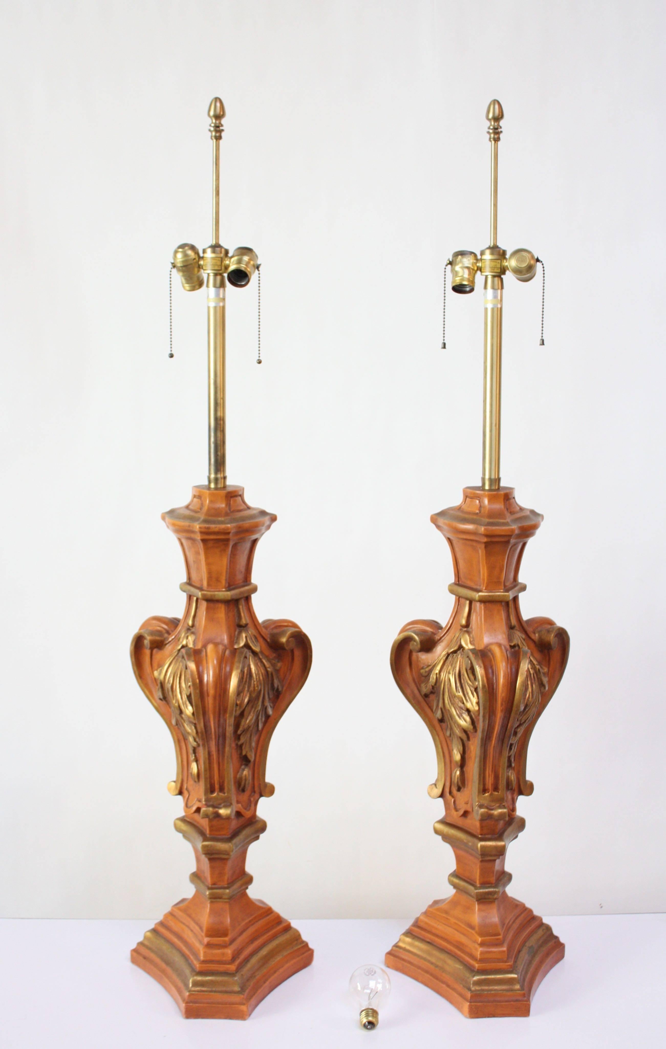 Pair of painted and gilded hardwood table lamps by renowned lighting manufacturer, Marbro, of Los Angeles, CA (circa early 1960s). Large, urn-shape examples with leaf decorative motif throughout. Intricately carved and painted with Dual pull chain