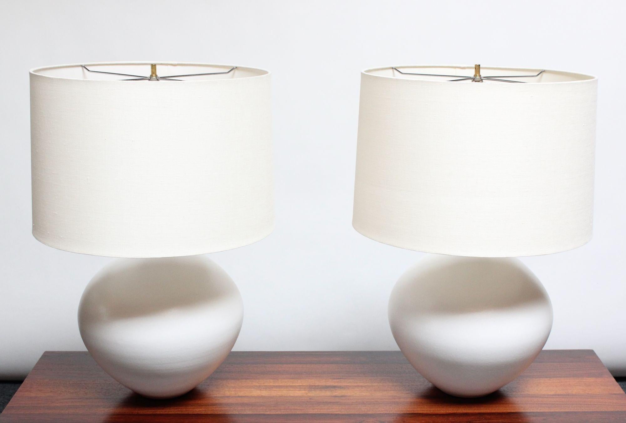 Large, bulbous-form ceramic table lamps in matte white glaze designed in the 1960s by Lee Rosen for Design Technics.
Shades are included but are neither original nor vintage.
Sculptural, modernist form with elegant brass stem and accents.
Incised