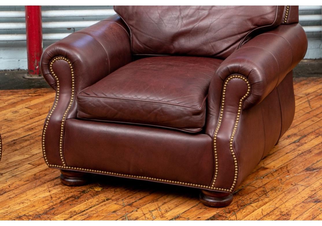 Pair of very comfortable arm chairs in oxblood leather by renowned American bench made leather crafters Hancock & Moore. The chairs feature best quality manufacture, flat bun foot and brass nail-head trim accent to the flat-panel arms. Of good size