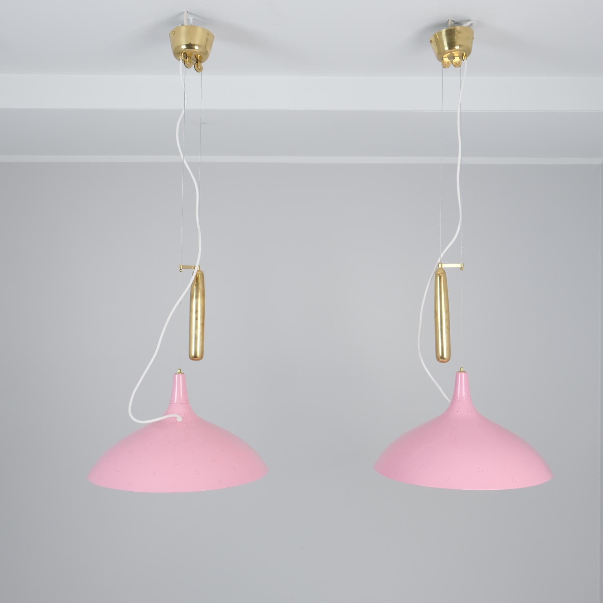 Una coppia di lampade da soffitto regolabili, modello A1965, disegnate da Paavo Tynell e prodotte da Taito Oy in Finlandia negli anni Cinquanta. Le lampade sono dotate di un meccanismo a contrappeso che permette di regolarne l'altezza, a