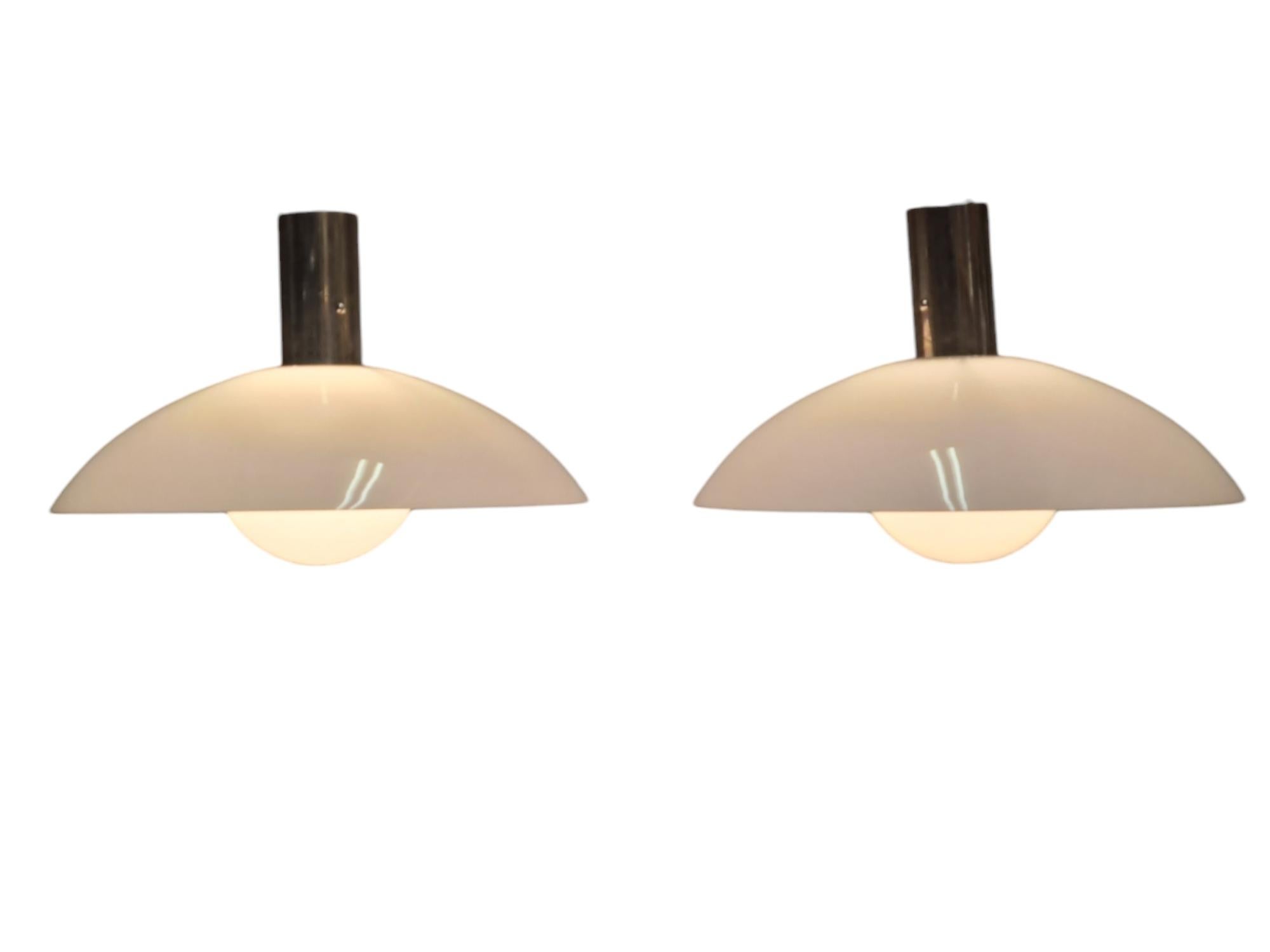 An elegant minimalist art deco pair of ceiling pendants by Paavo Tynell and manufactured by Taito from the 1930s. This pair, along other lamps on our listings, came from the Ilveslinna building in Jämsänkoski and were all commissioned by Paavo