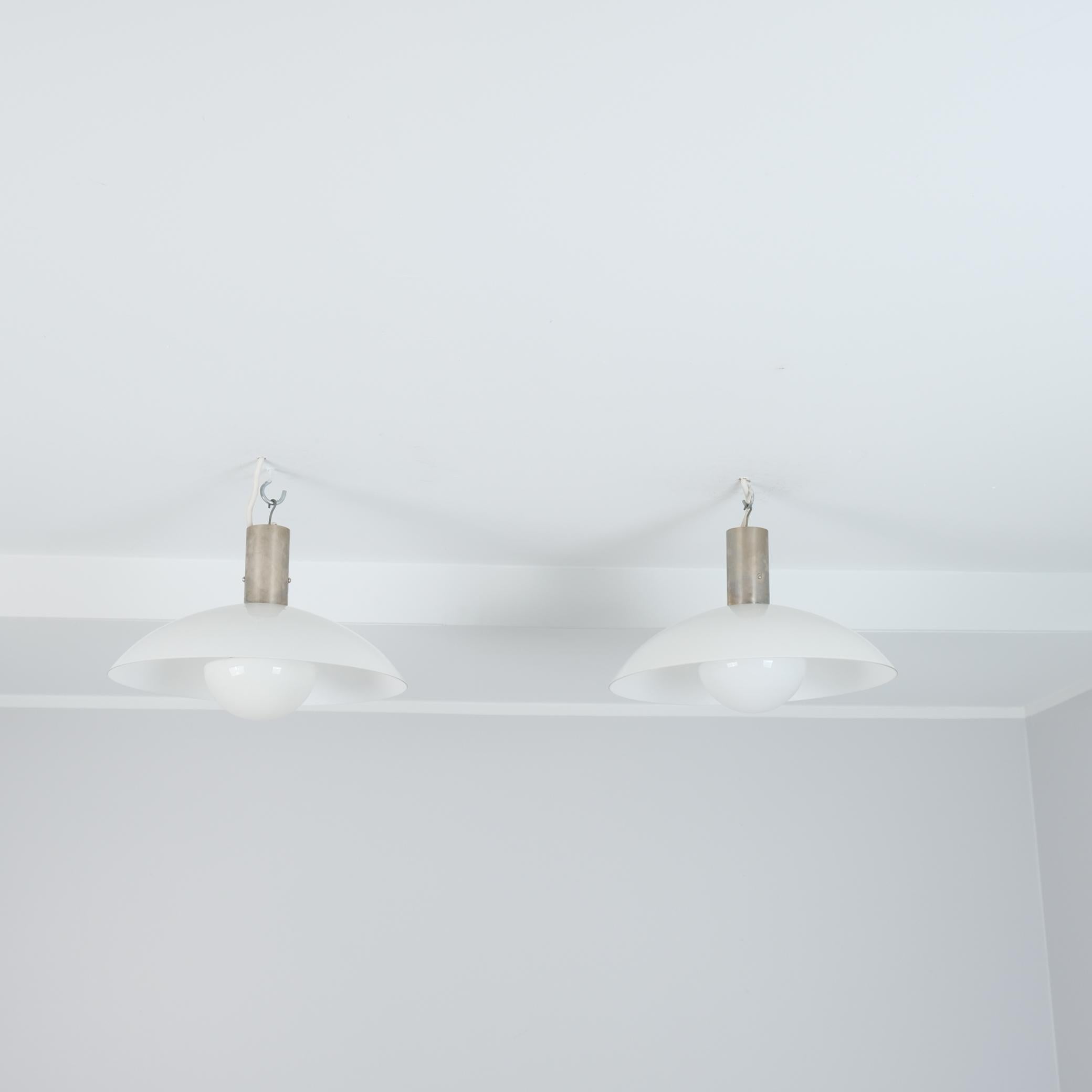 Un'elegante coppia di pendenti da soffitto in stile art déco, realizzati da Paavo Tynell e prodotti da Taito negli anni '30. Questa coppia, insieme ad altre lampade presenti nel nostro elenco, proviene dall'edificio Ilveslinna di Jämsänkoski ed è