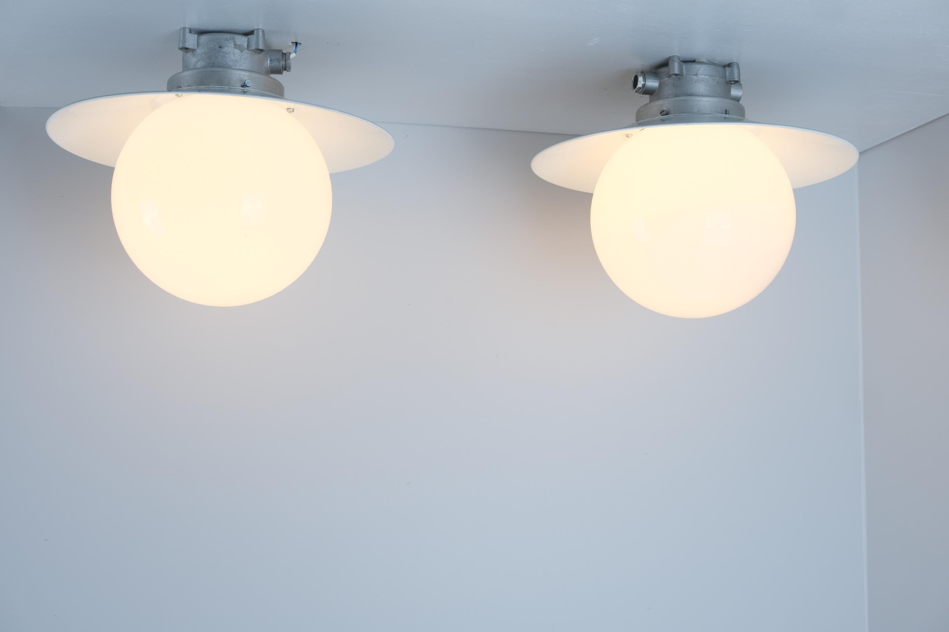 Una coppia di lampade da esterno/interno Paavo Tynell in stile industriale, modello H9-100. Le lampade hanno un bellissimo e originale paralume in metallo di colore bianco/grigio, facile da integrare in qualsiasi interno o esterno, abbinato a