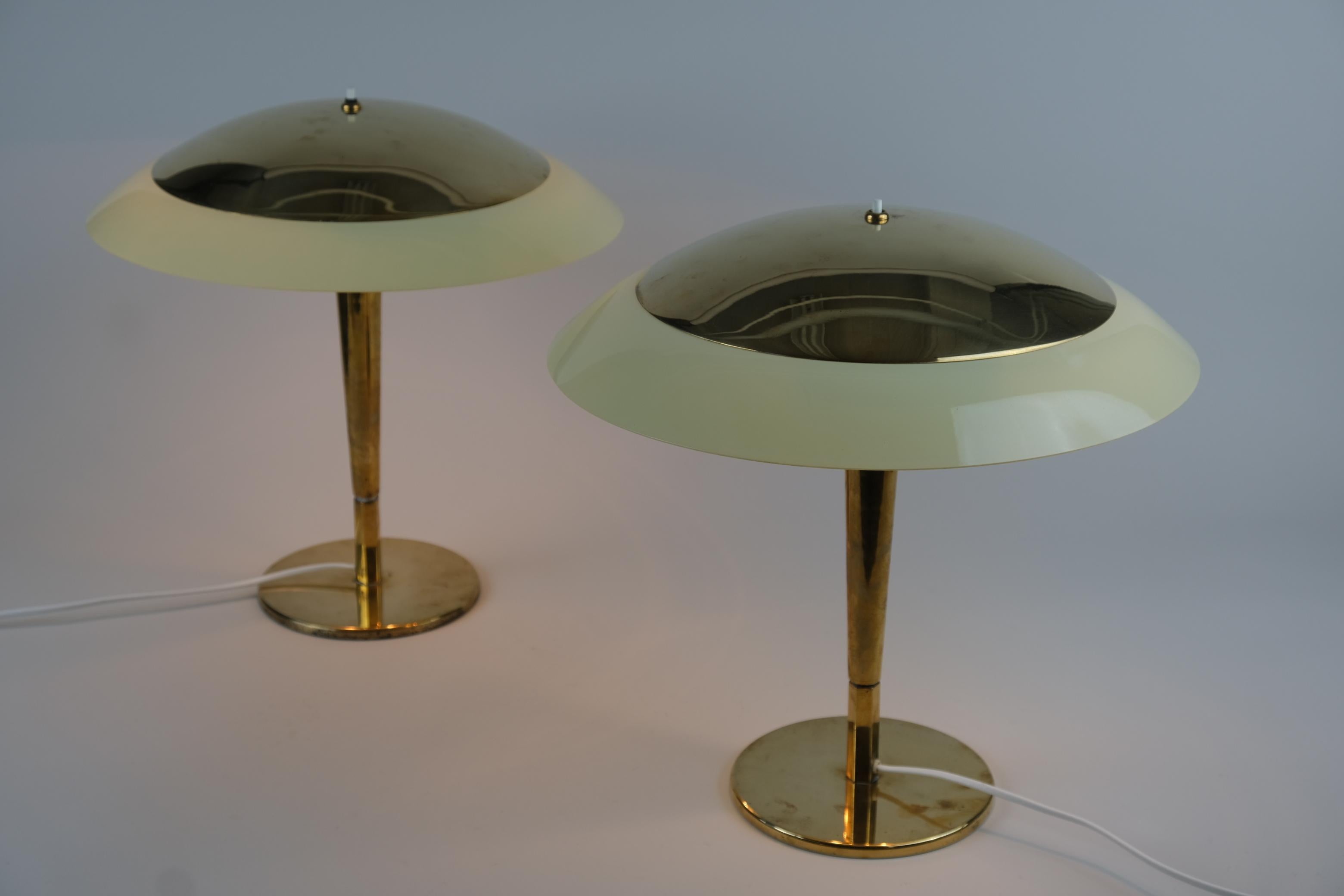 A beautiful pair of Paavo Tynell lamps that rarely come as a pair from the same place. These model 5061 from 1940s' are in beautiful original condition and only slightly polished.

The shade of this well designed majestic table lamp consists of two