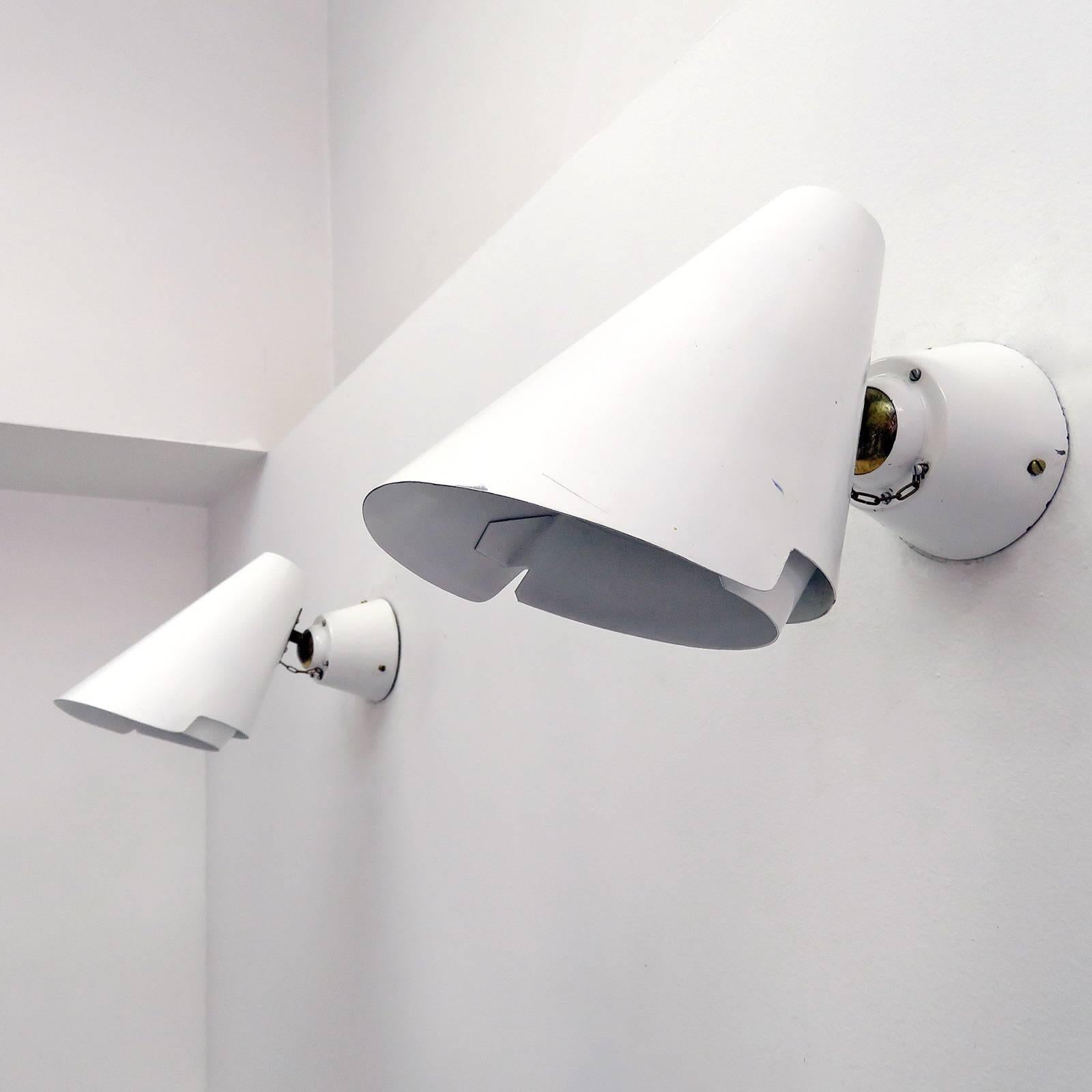 Stunning pair of articulate wall lights, model 2351 by Paavo Tynell for Idman, Helsinki, Finland, circa 1955, in white enameled steel with large brass ball joint, chain detail and oversized back plate, retain original makers mark, one E27 socket per