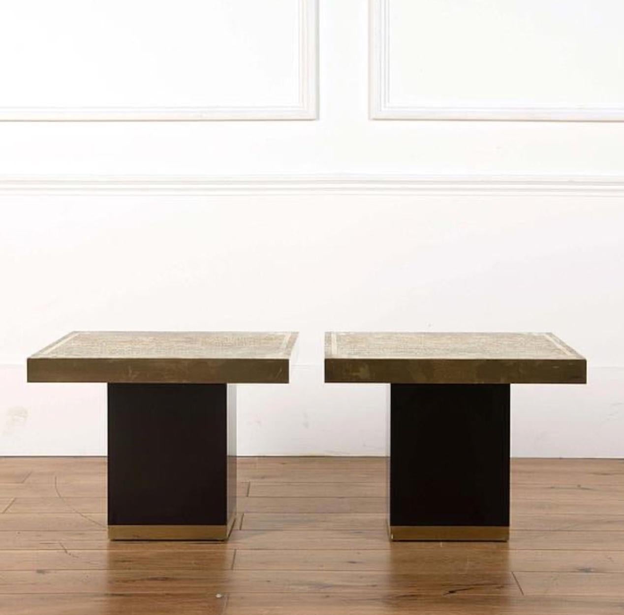 Pair of stylish Paco Rabanne 1970s side or end tables with shiny black cube bases, wrapped brass accenting, and thick square surface tops. A sleek and graphic set with wonderful sharp modern lines. 

Spain, circa 1970

Dimensions: 16H x 21W x