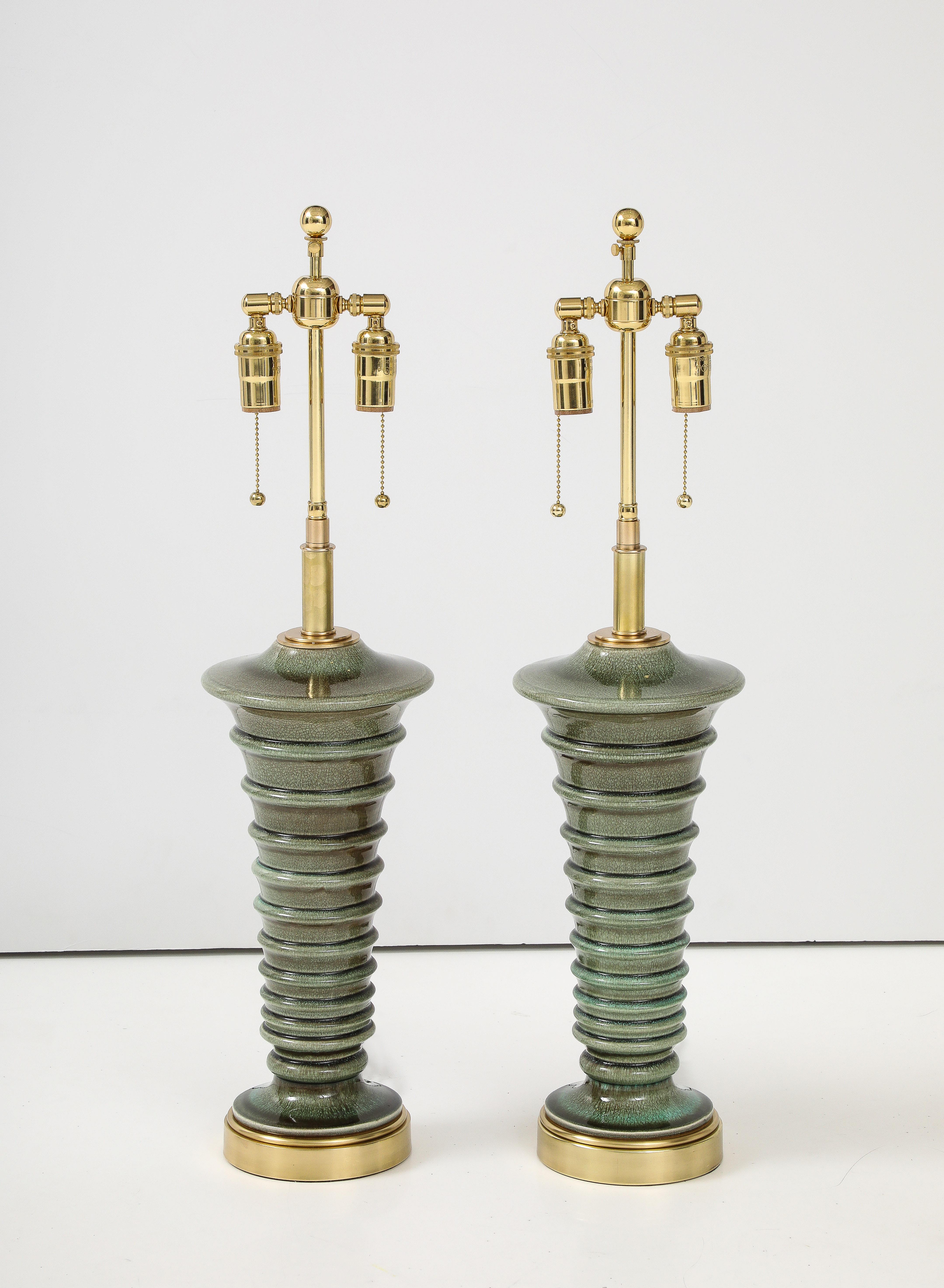 Paire de lampes en céramique en forme de pagode, datant des années 1960, avec une belle glaçure moussée.
Les lampes reposent sur des bases en laiton poli et elles ont été nouvellement câblées avec des doubles grappes ajustables en laiton poli, des