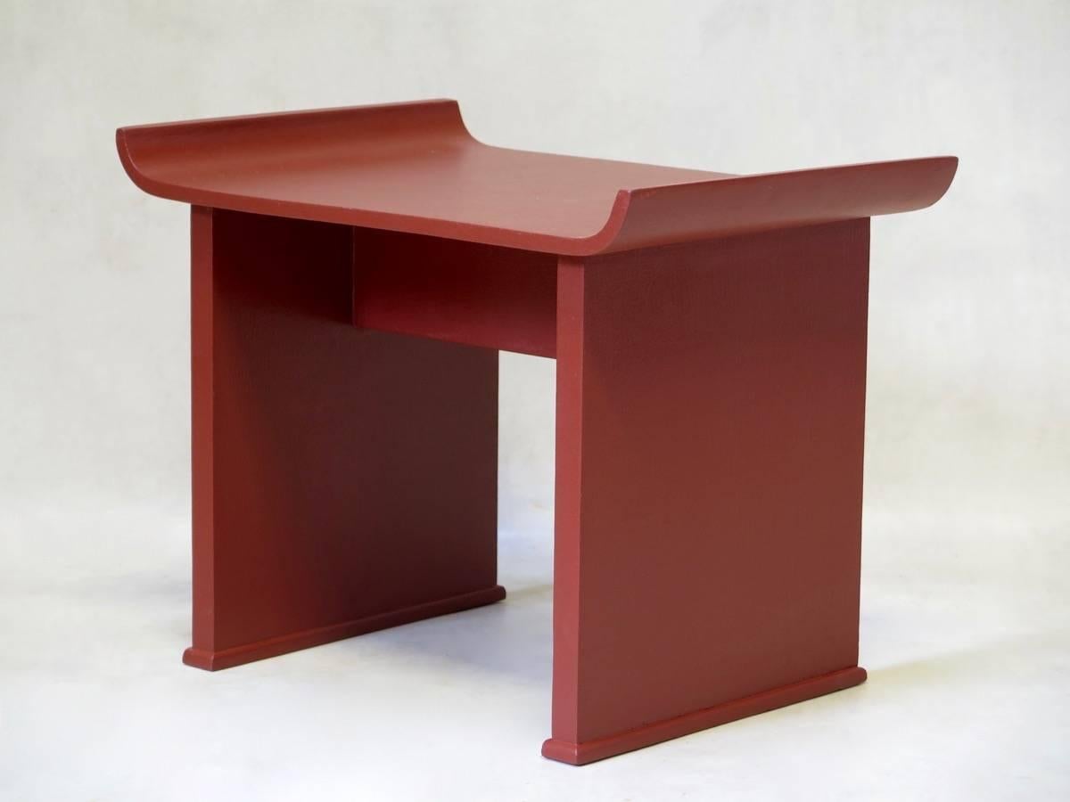Minimalistic pair of red-painted wooden side tables, the tops turning upwards at the edges, giving them an Oriental air.