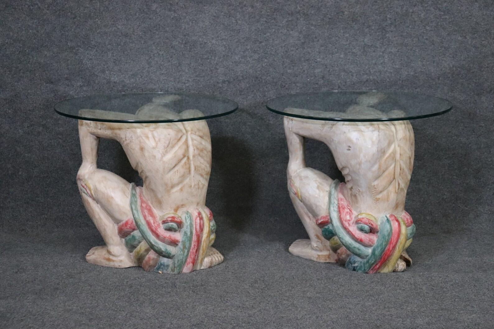 Dimensions: H: 20in W: 23 3/4in D: 23 3/4in
This is an exceptional Pair of Carved Figural Glass Top end tables perfect for any living room, office, or bedroom. These end tables are extremely unique with the carved figures holding up the glass. These