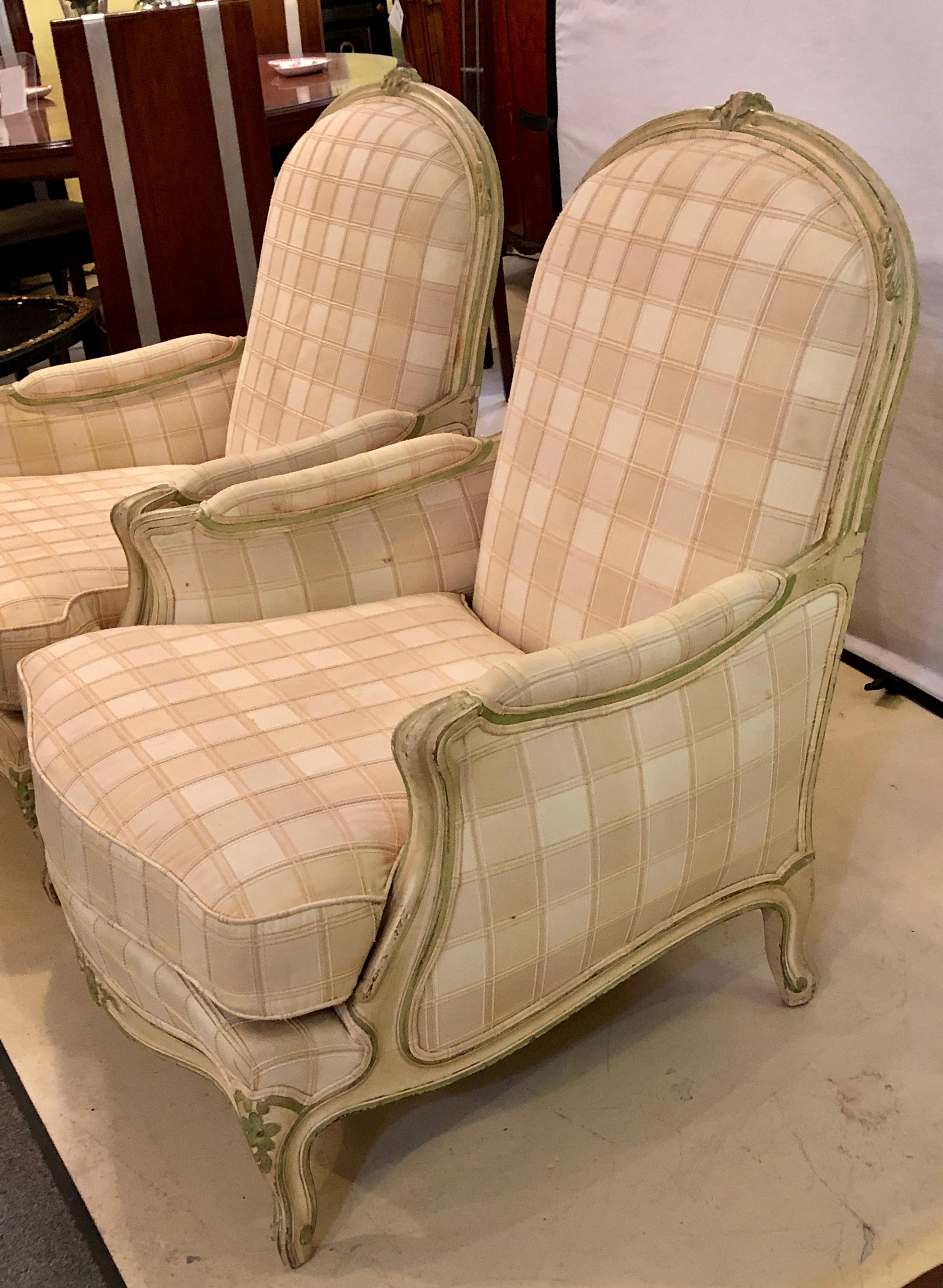 Pair of paint decorated Louis XV style bergeres chairs each having a plaid fabric with extra wide seat and back rests. These very comfortable and sturdy chairs would glow in any setting.