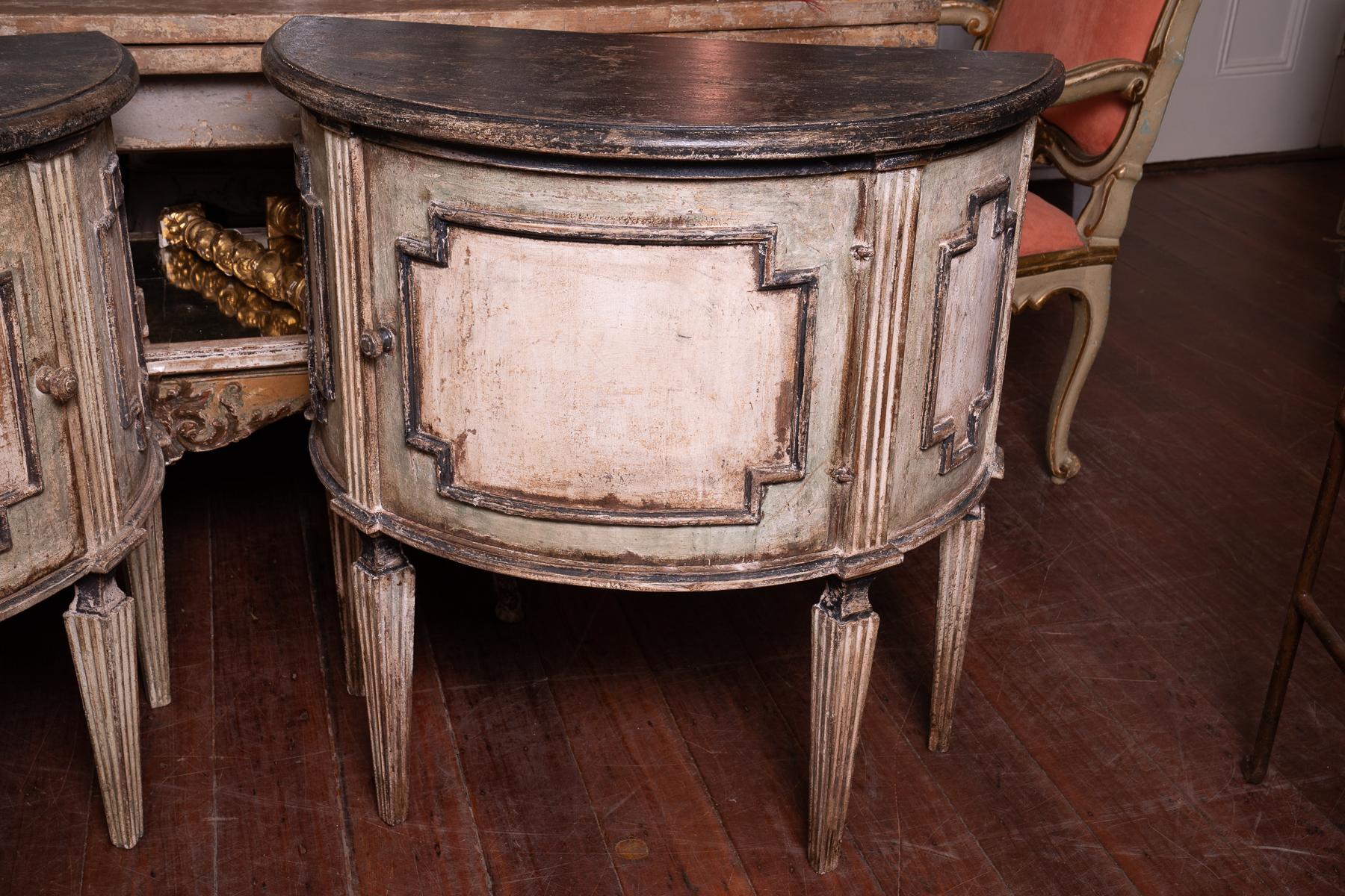 19th century painted Italian pair of petit demilune cabinets.