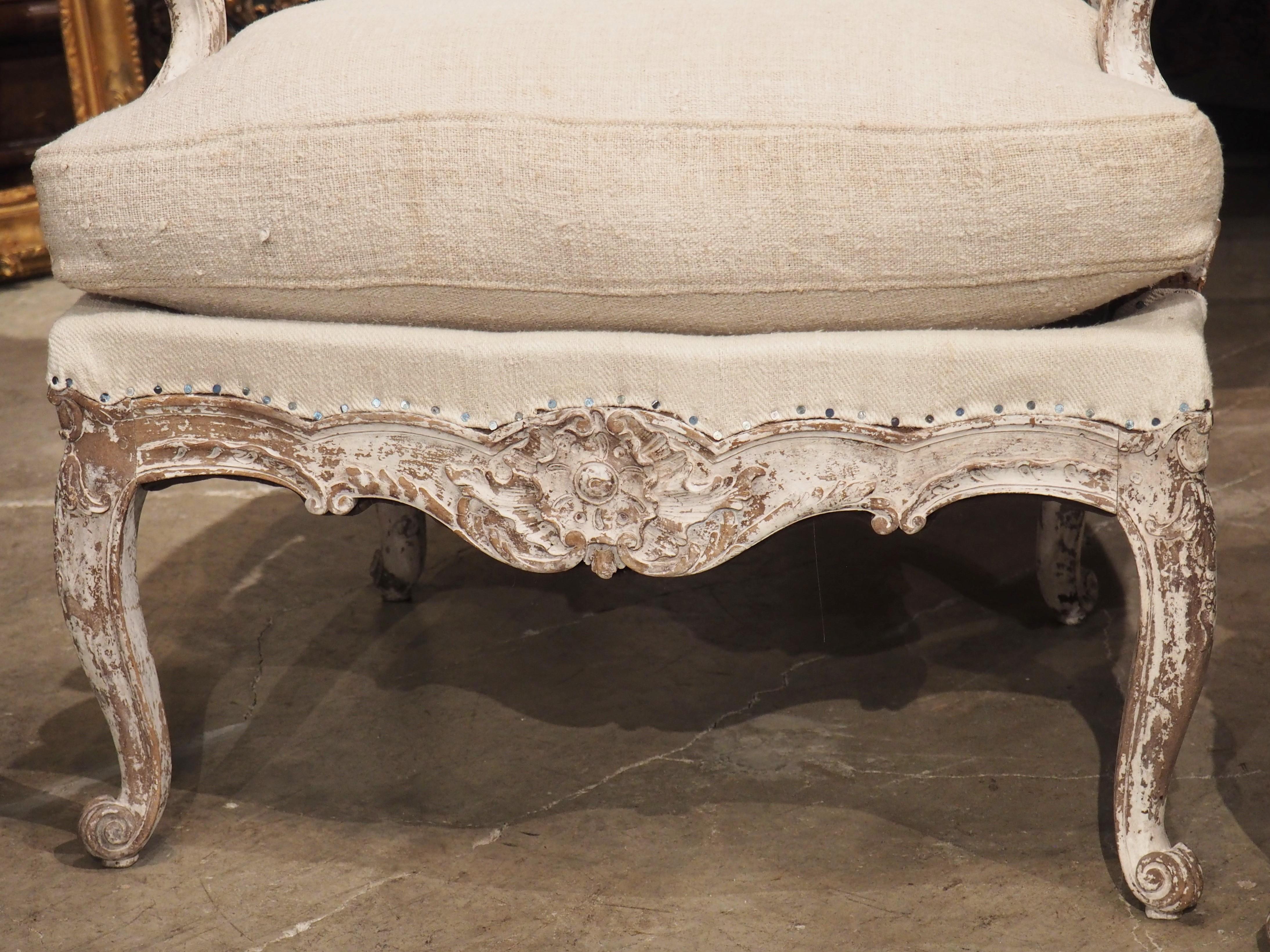 One of the most characteristic decor from the Regence period is the coquille, or scalloped shell. Often appearing as central motifs on consoles, tables, and armoires, our pair of Regence style fauteuil armchairs have a large coquille medallion