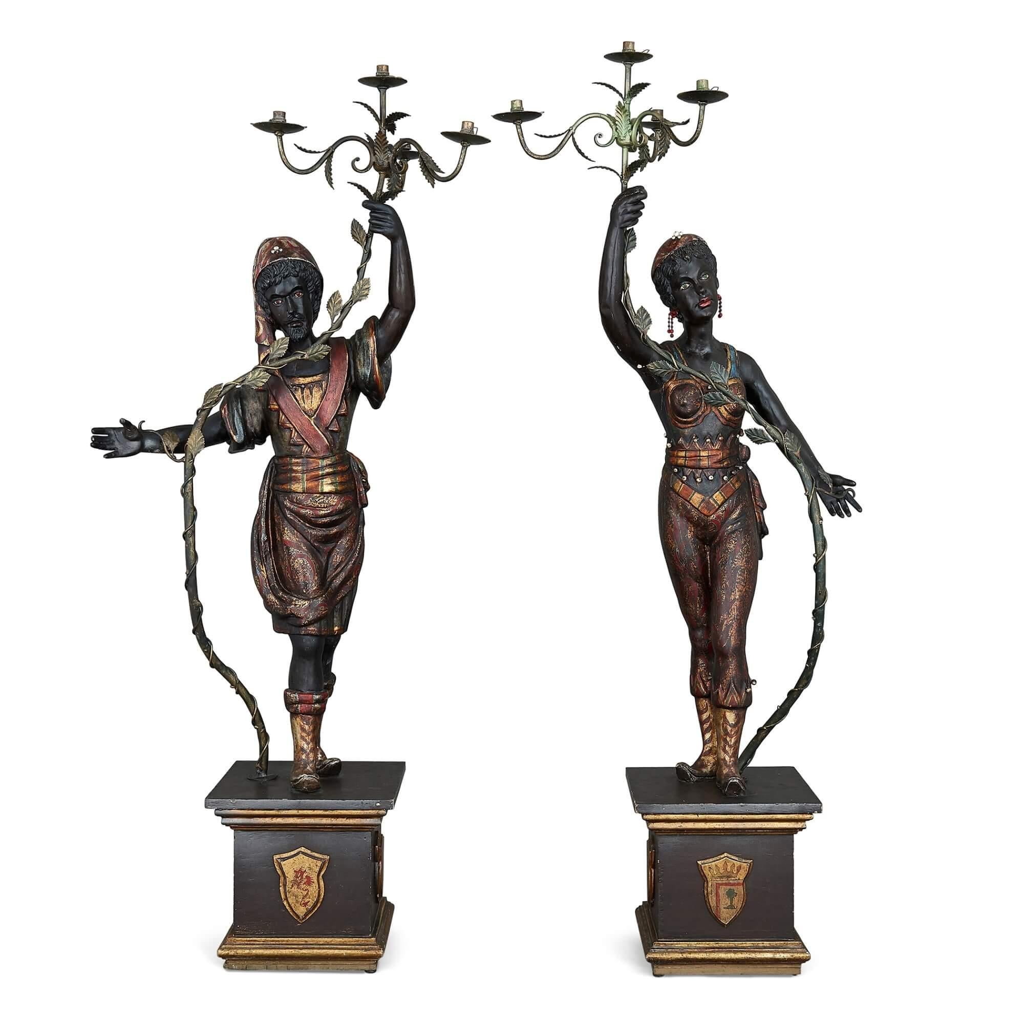 Pair of painted and ebonised wood floor-standing figurative candelabra
Italian, 19th century
Measures: Male figure: Height 192cm, width 77cm, depth 40cm
Female figure: Height 192cm, width 66cm, depth 40cm

The figurative candelabra in this pair