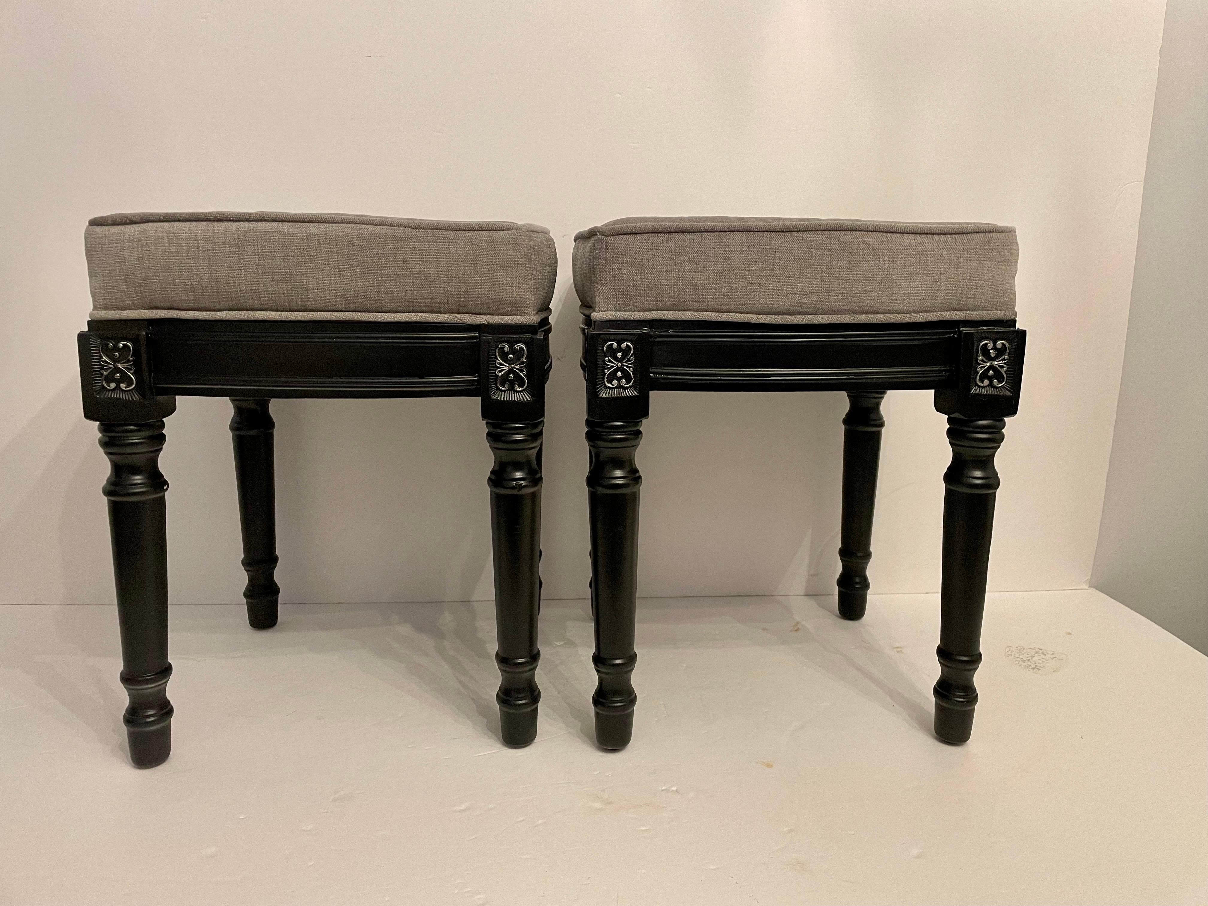 Pair of Black Painted and Silver Gilt Regency Style benches with newly upholstered seats in grey. Wear consistent with age and use.