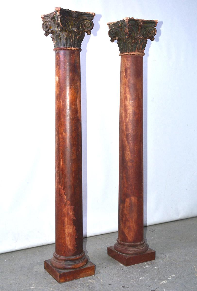 Das Paar antiker korinthischer Säulen ist mit einem marmorierten Effekt auf jeder Basis und jedem Schaft bemalt und hat schwarze Kapitelle, über denen mittig Zapfen angebracht sind. 

Höhe bis zur Spitze - 44
