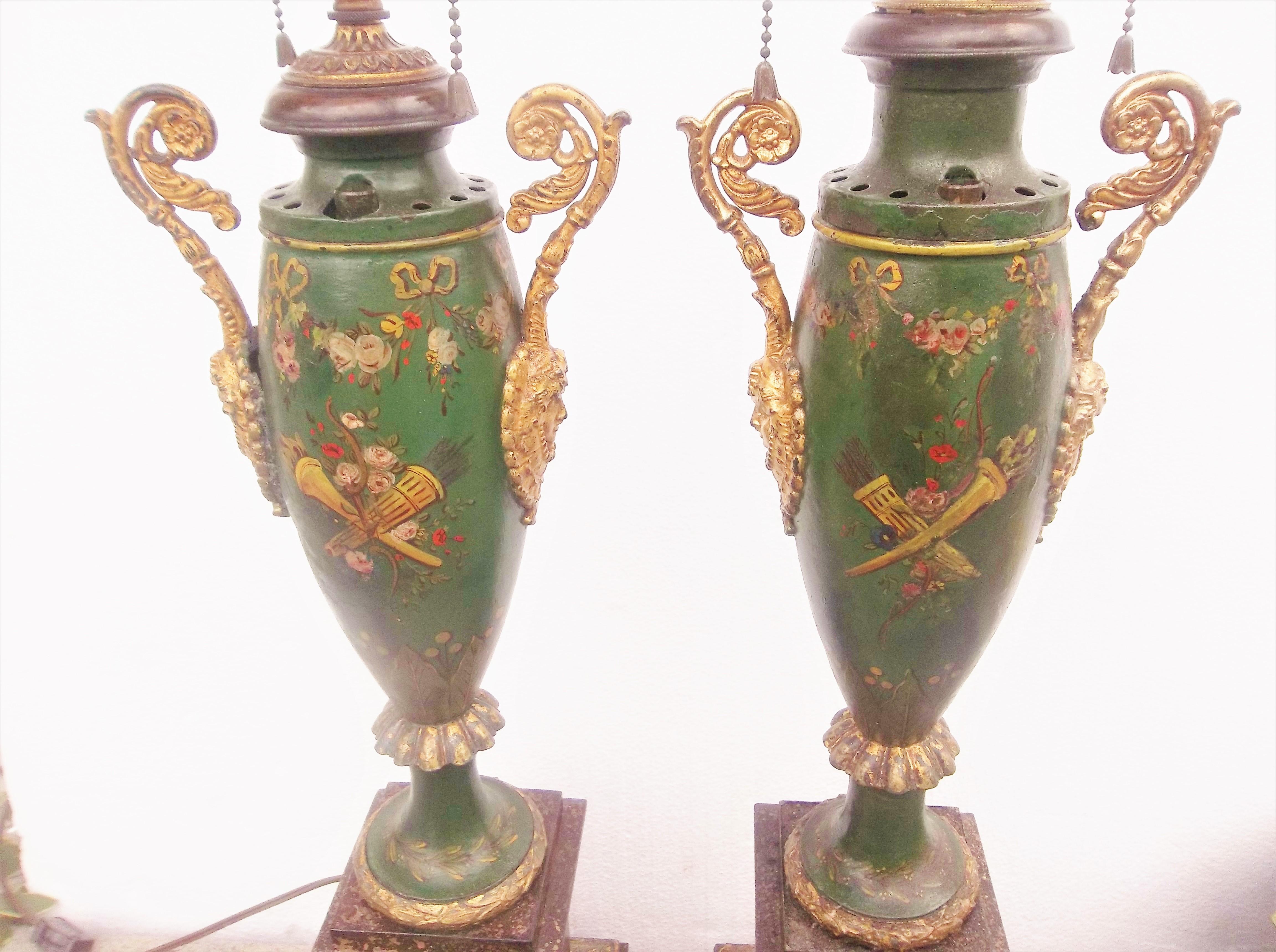 The shade(s) and bases(s) in a faux porphyry finish with gilt decorations of baskets, laurels, festoons and wreaths. Each parfum with a green ground and decorated with floral garlands, bow and arrows and torches. The gilded handles on the lamp each
