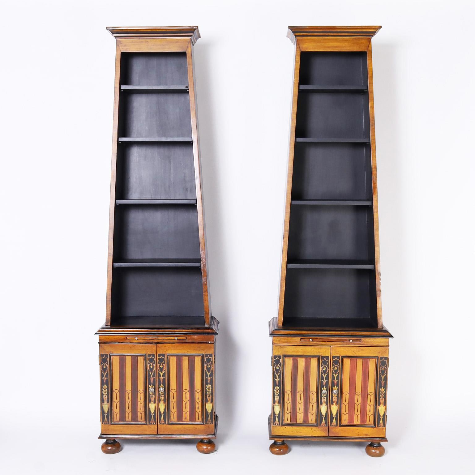Impressive pair of bookcases or etageres with a dramatic stylized obelisk form crafted in hardwoods and decorated with classic Adam style designs under a contrived aged finish complete with fly specks.
