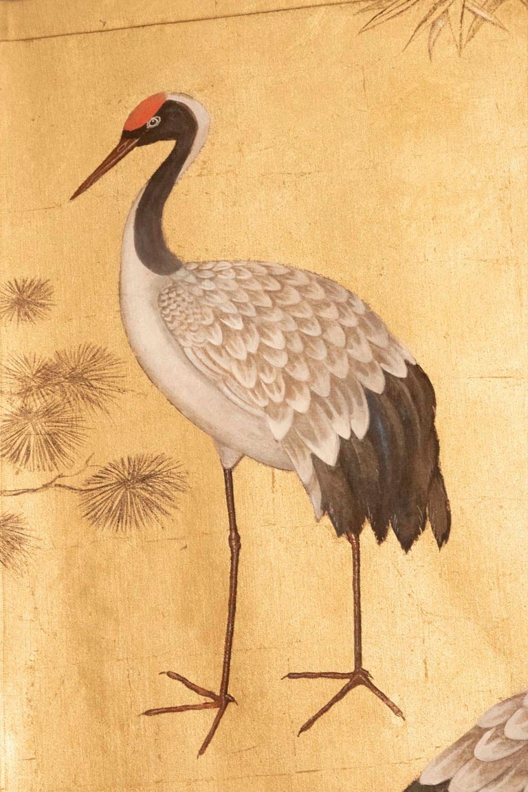 Pair of Japanese style canvas figuring cranes birds. On each canvas, a crane birds couple, with grey, black and red plumage, is surrounded by bamboos and foliage on a gilt background.

Linen raw canvas hand painted with natural pigments and