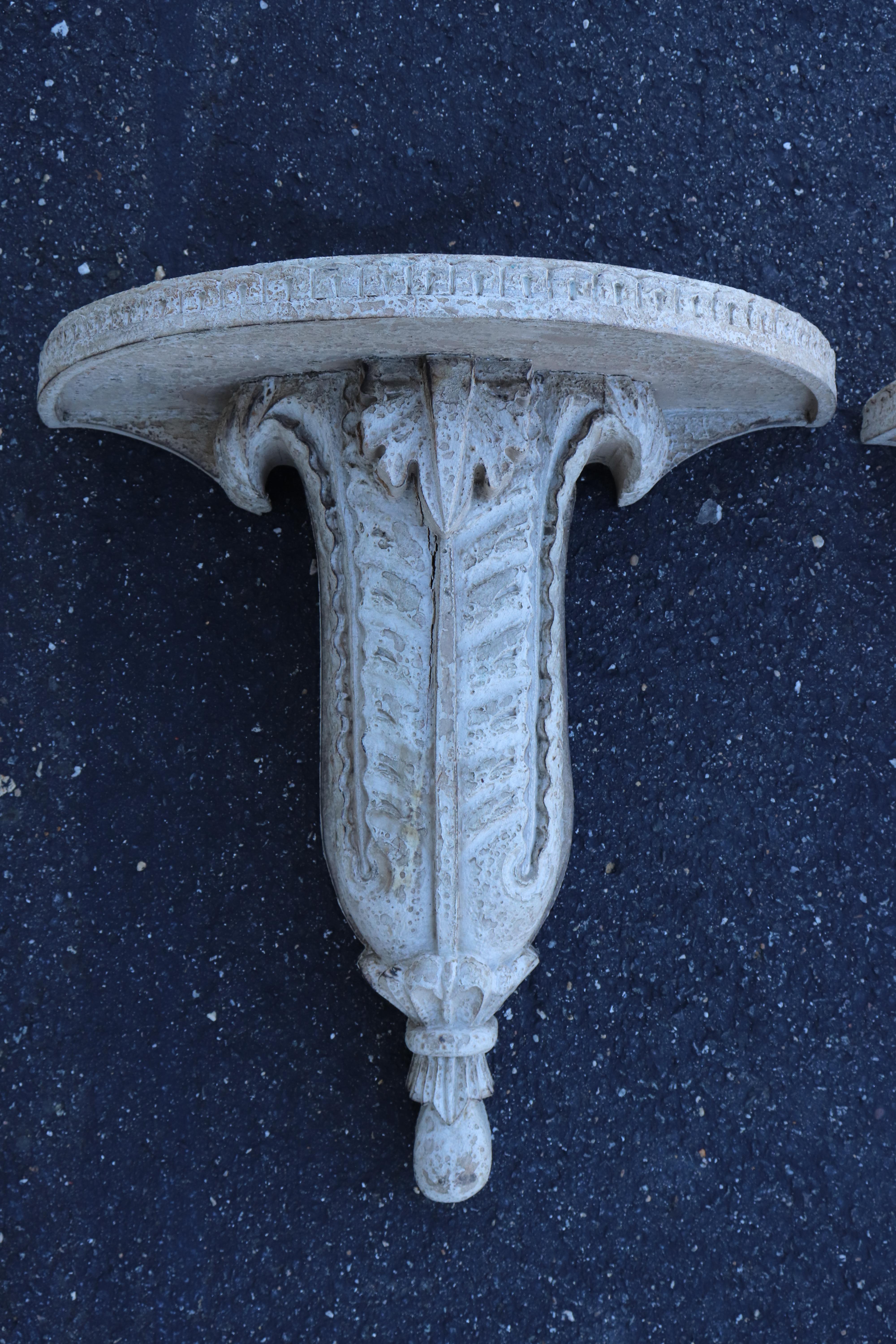 This is a superb carved white-washed or painted pair of French Hollywood Regency wall shelves or brackets. They are in antique condition with their original finish and patina with signs of age and wear to the painted surface as shown. They date to