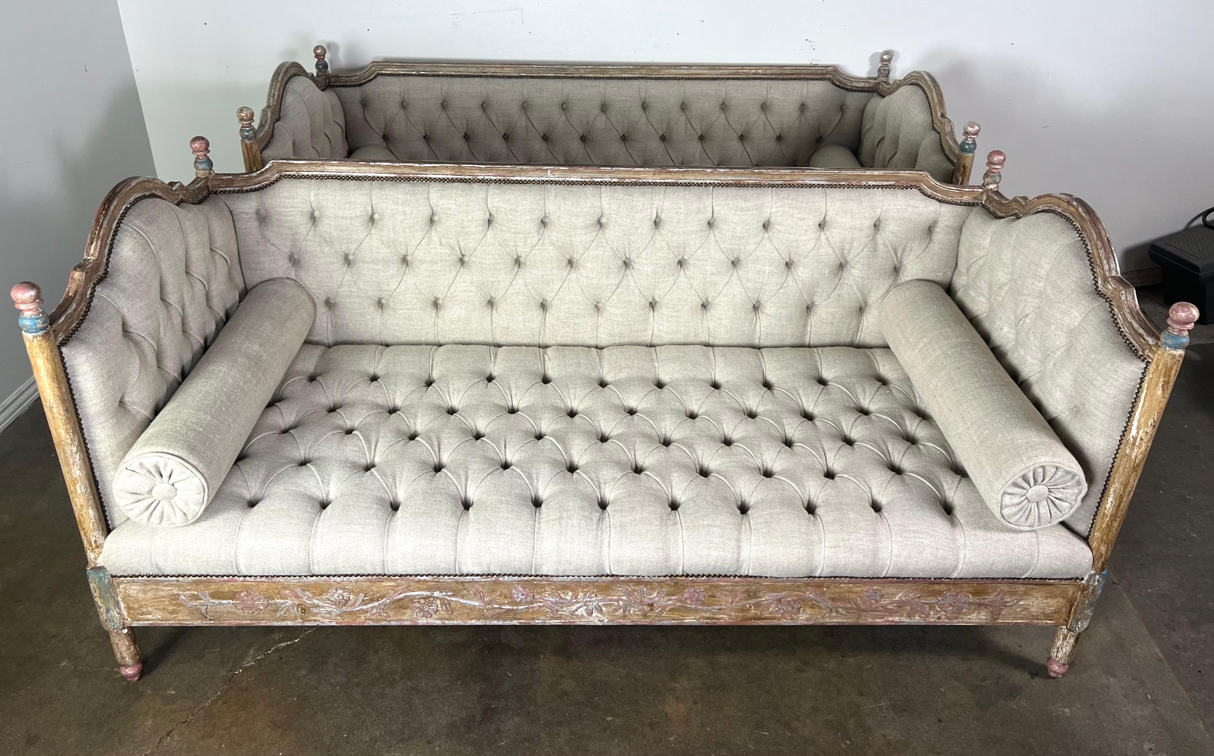 French painted daybed (a pair is available) with a refined and elegant design.  The daybed features a tufted Belgium linen adding texture and a luxurious feel to the piece.

The wooden frame of the daybed is ornate and weathered, with a distressed