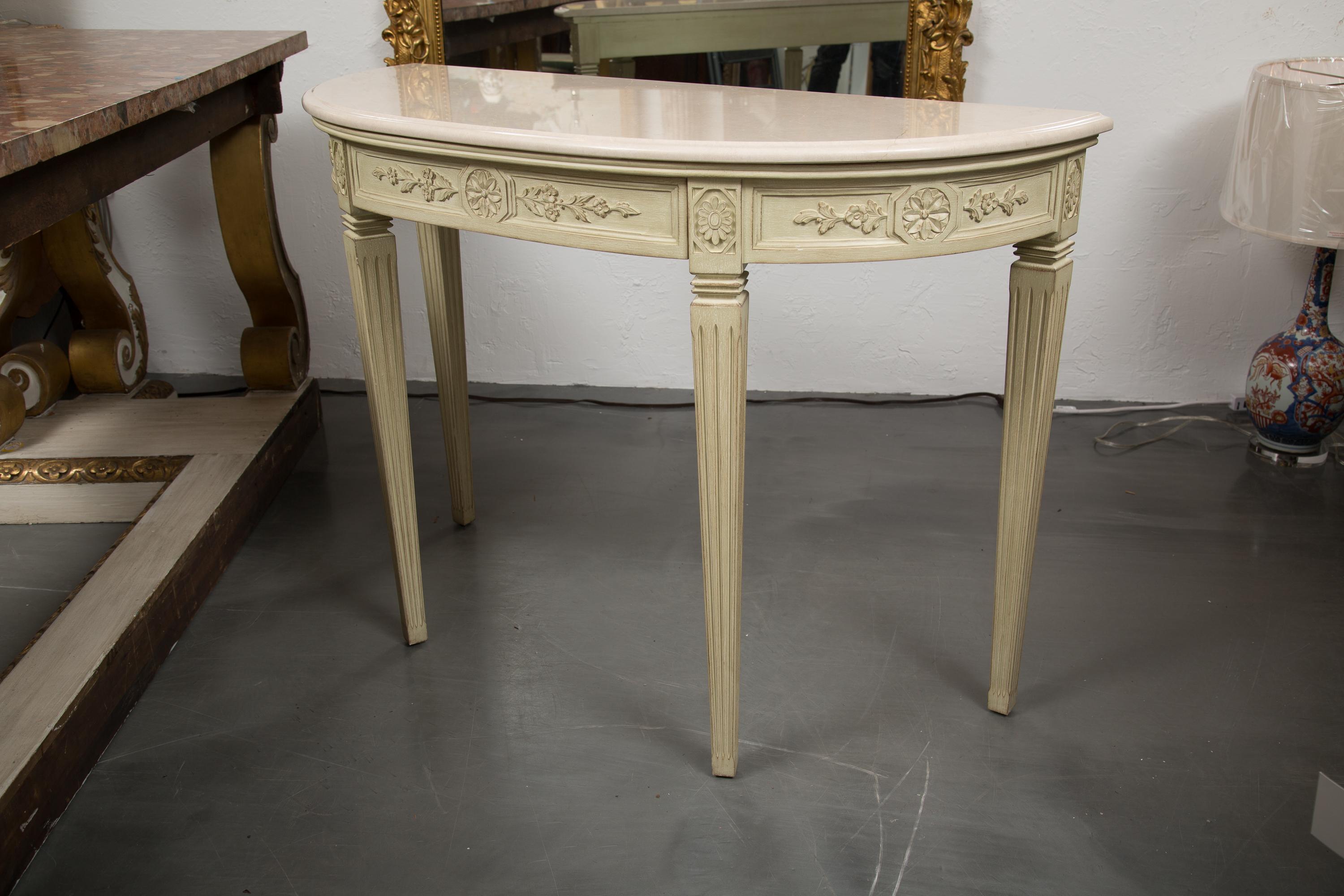 These are a Classic Italian hand carved and painted console tables. Each has a cream marble top over a carved frieze containing a central drawer. Both consoles are supported by square tapered fluted legs. Priced as a single item.