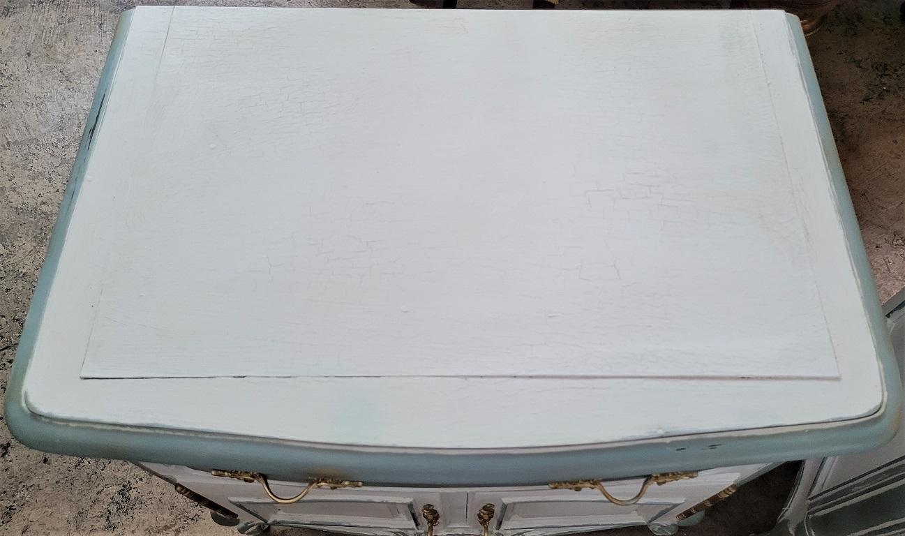Presenting a lovely pair of painted French Country nightstands.

Painted and distressed in classic French Country fashion !

Matching pair with central floral medallion, curved and bun feet, Louis XV style gold plated hardware.

4 Tone effect
