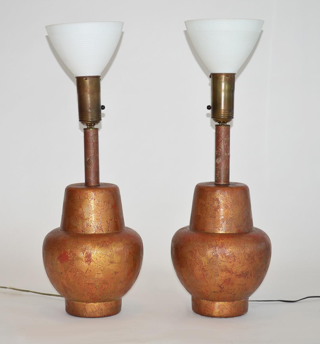 Pair of Gold Leaf Gilded Wood Gesso Lamps by James Mont, USA, 1950s 
A pair of bulbous form Asian-inspired, heavy striated gesso design, red painted and gold gilt over wood table lamps with original glass shades and linen shades. Some chips and loss