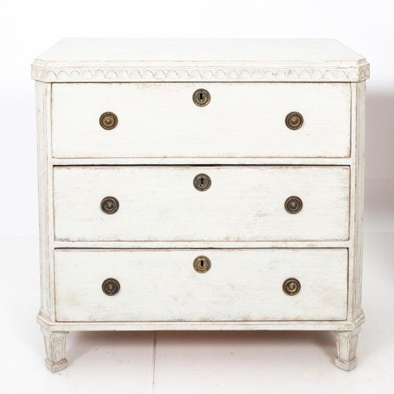 Pair of white painted Gustavian chest of drawers with metal hardware and historic paint that features original patina, circa 1880s. Please note of wear consistent with age including minor paint loss.