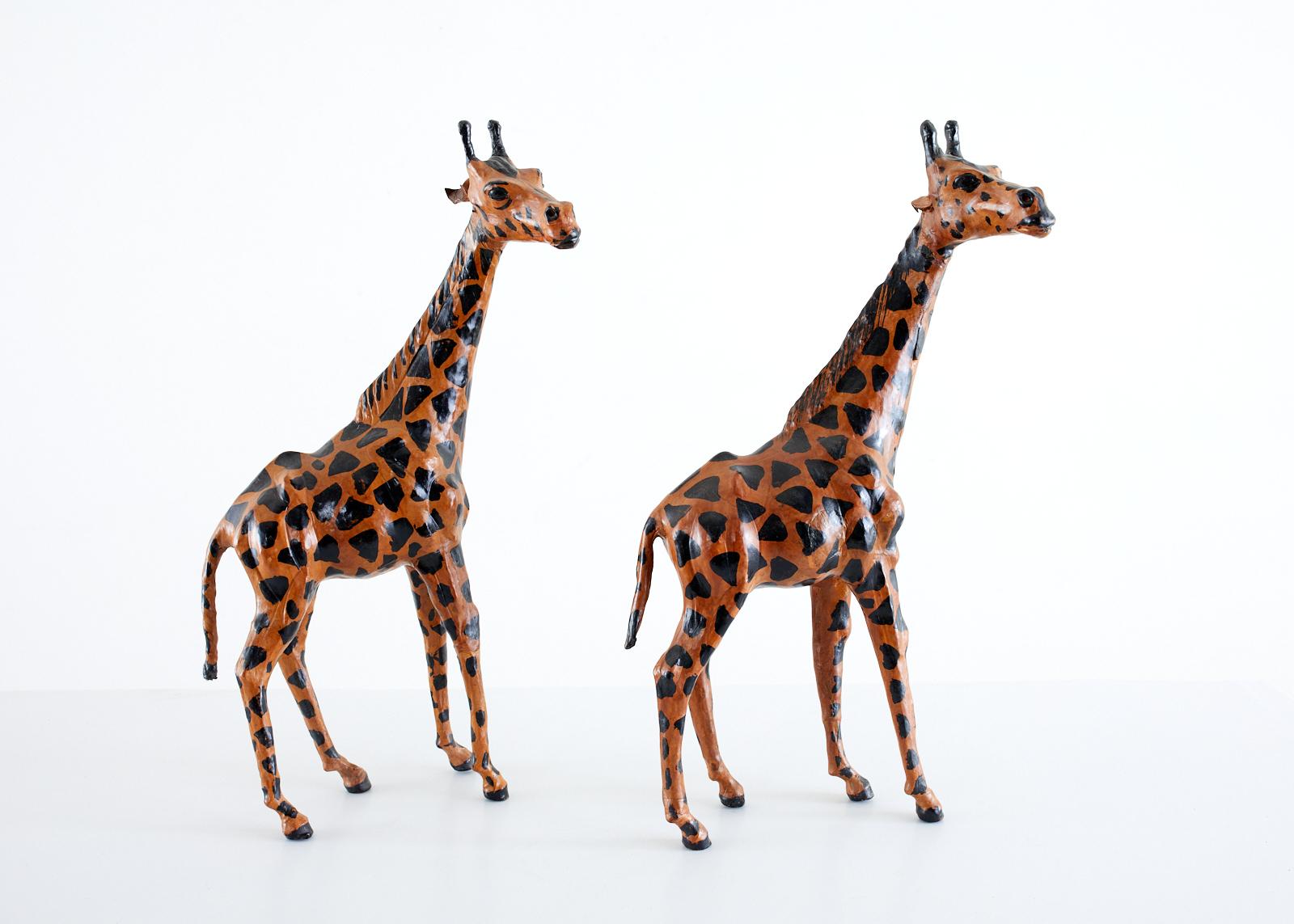 Charming pair of hand painted leather giraffe sculptures featuring a geometric pattern body and life like heads. Beautifully hand-crafted with expressive faces.